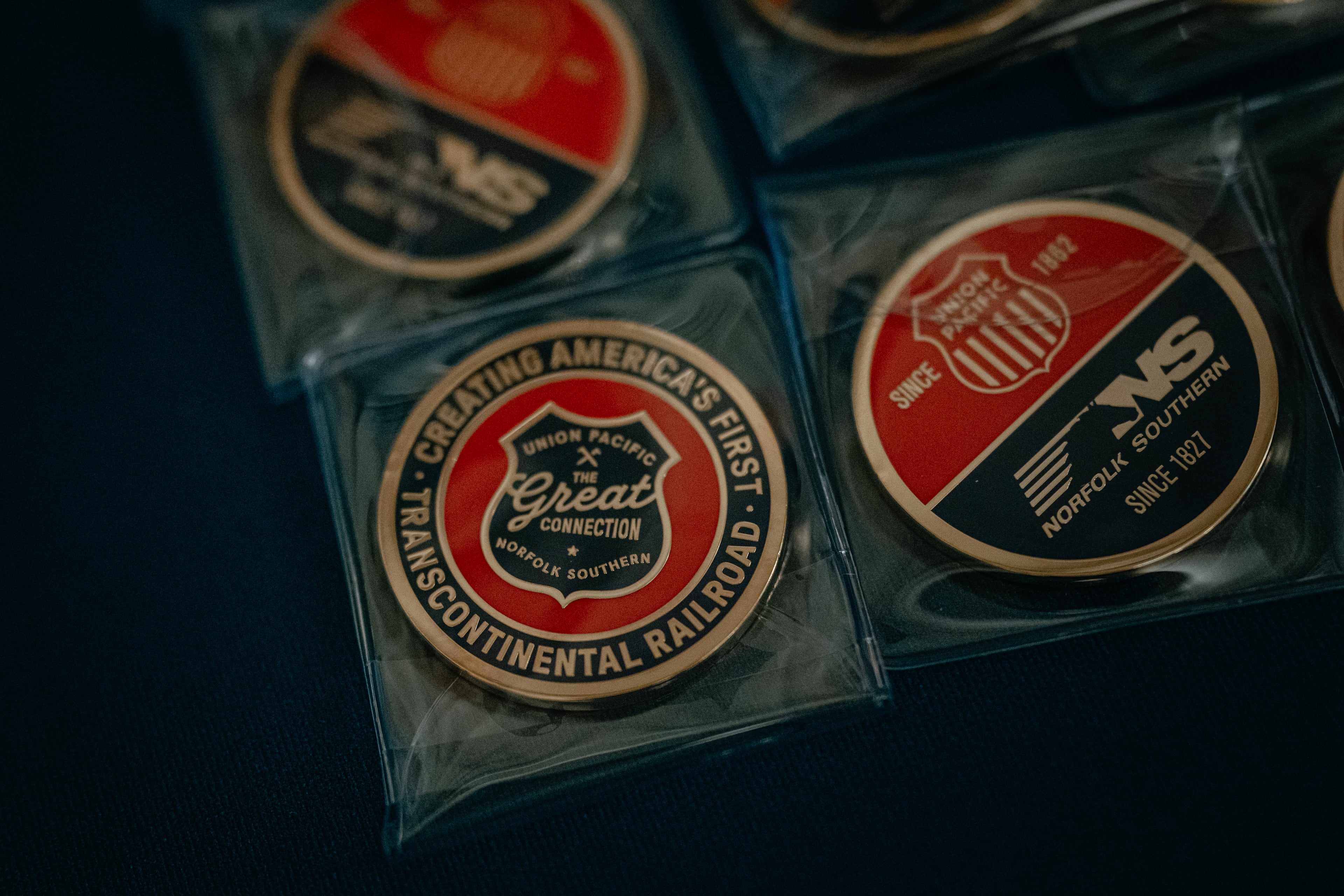 Collector coins labeled “The Great Connection,” referring to the proposed merger between Union Pacific and Norfolk Southern, sit on a table at Railway Age’s Next Generation Freight Rail conference at the Union League Club of Chicago on Tuesday, March 10, 2026. (Jamie Kelter Davis for the AJC)