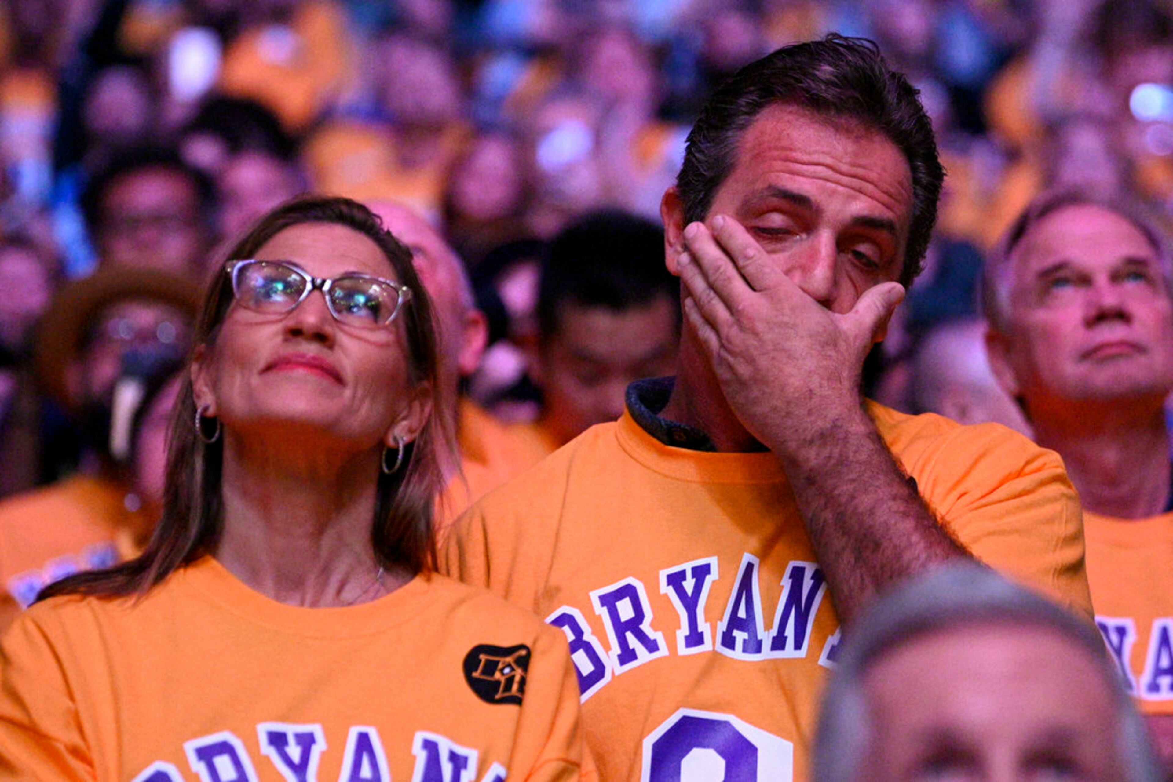 A spectator wipes his face from tears while watching a tribute video for the late Los Angeles Lakers' Kobe Bryant, prior to the Lakers' NBA basketball game against the Portland Trail Blazers in Los Angeles, Friday, Jan. 31, 2020. (AP Photo/Kelvin Kuo)