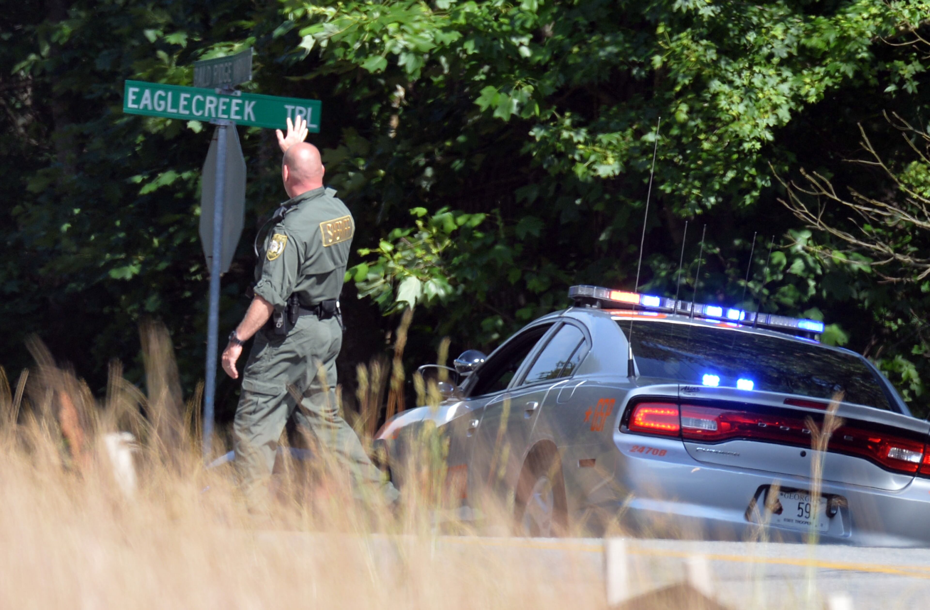 Law enforcement blocks streets near the home of Dennis Marx, the suspect in the Forsyth County Courthouse shooting, in Cumming on Friday, June 6, 2014.