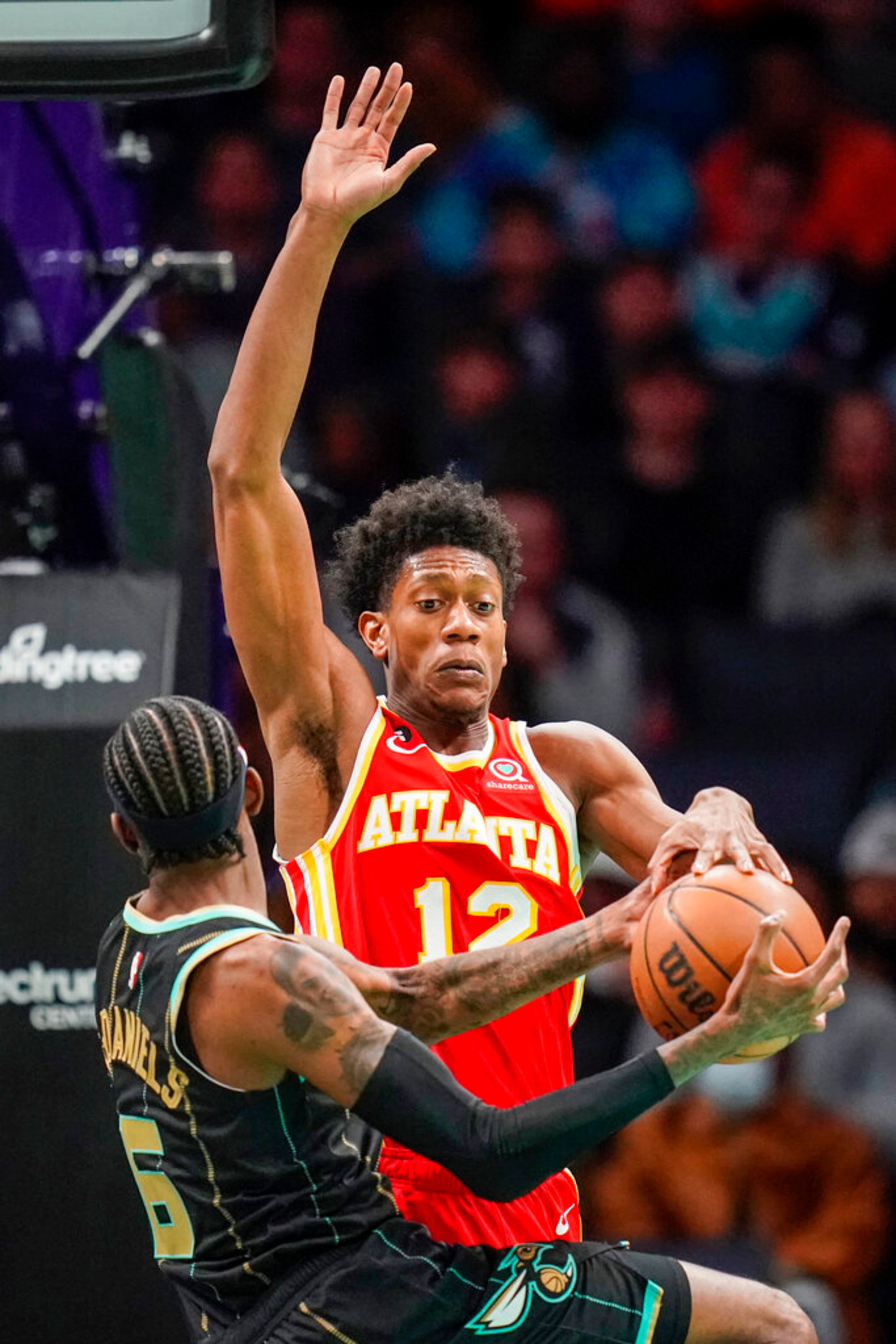 Atlanta Hawks forward De'Andre Hunter, rear, blocks a shot by Charlotte Hornets forward Jalen McDaniels, front, during the second half of an NBA basketball game Friday, Dec. 16, 2022, in Charlotte, N.C. (AP Photo/Rusty Jones)