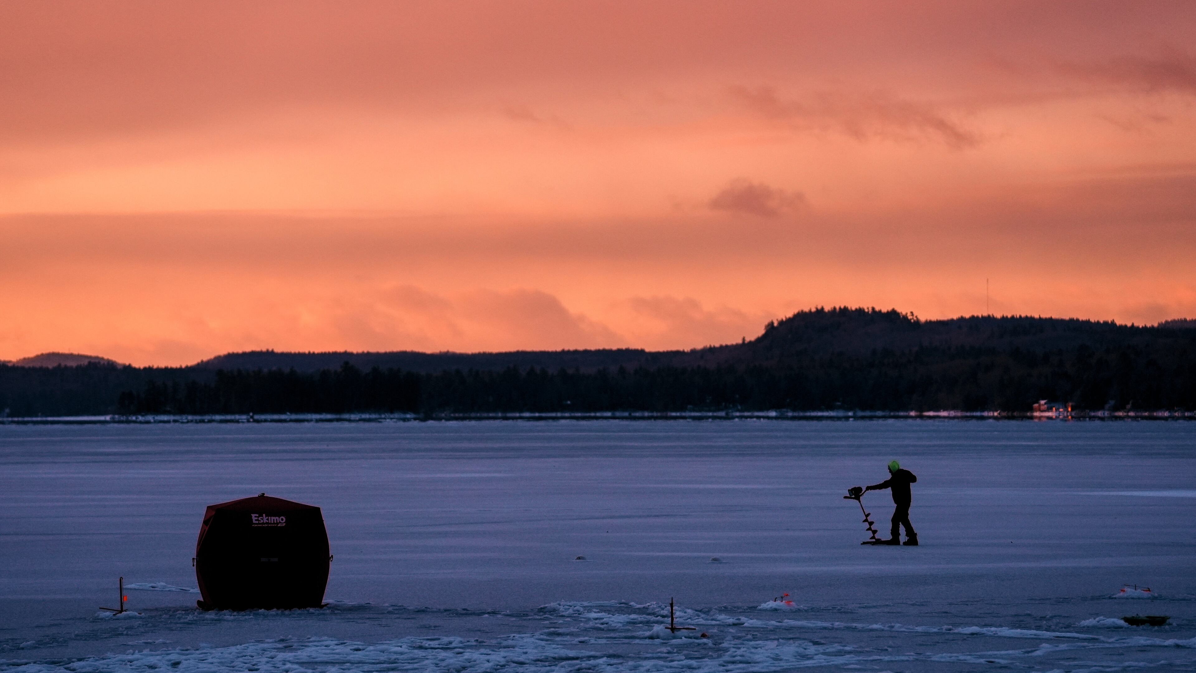 An ice fisherman starts his auger before drilling a hole in the ice on Long Lake following yesterday's freezing rainstorm, Tuesday, Dec. 30, 2025, in Harrison, Maine. (AP Photo/Robert F. Bukaty)