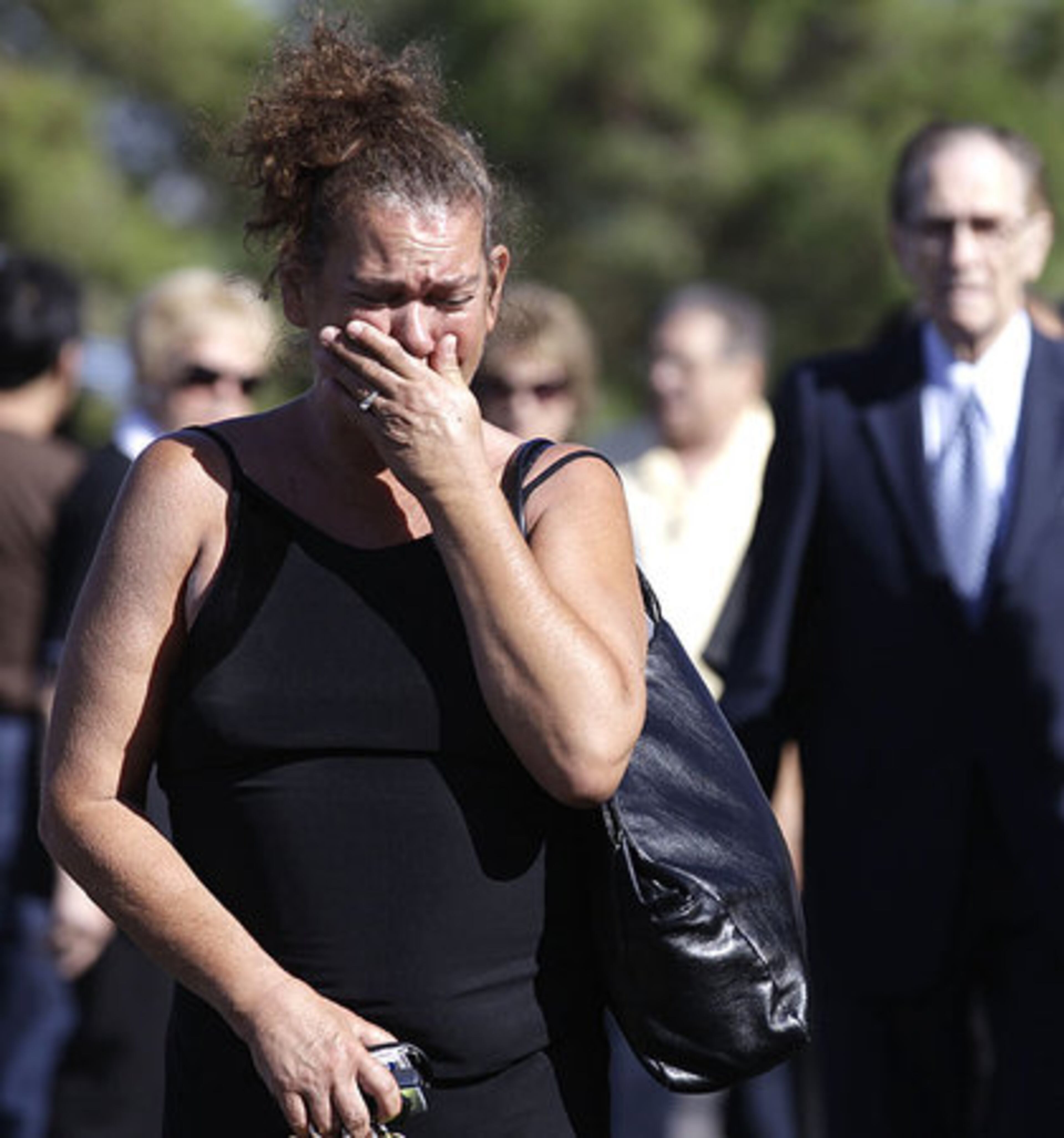 A mourner cries as she walks to the chapel for the funeral service for Tony Curtis.