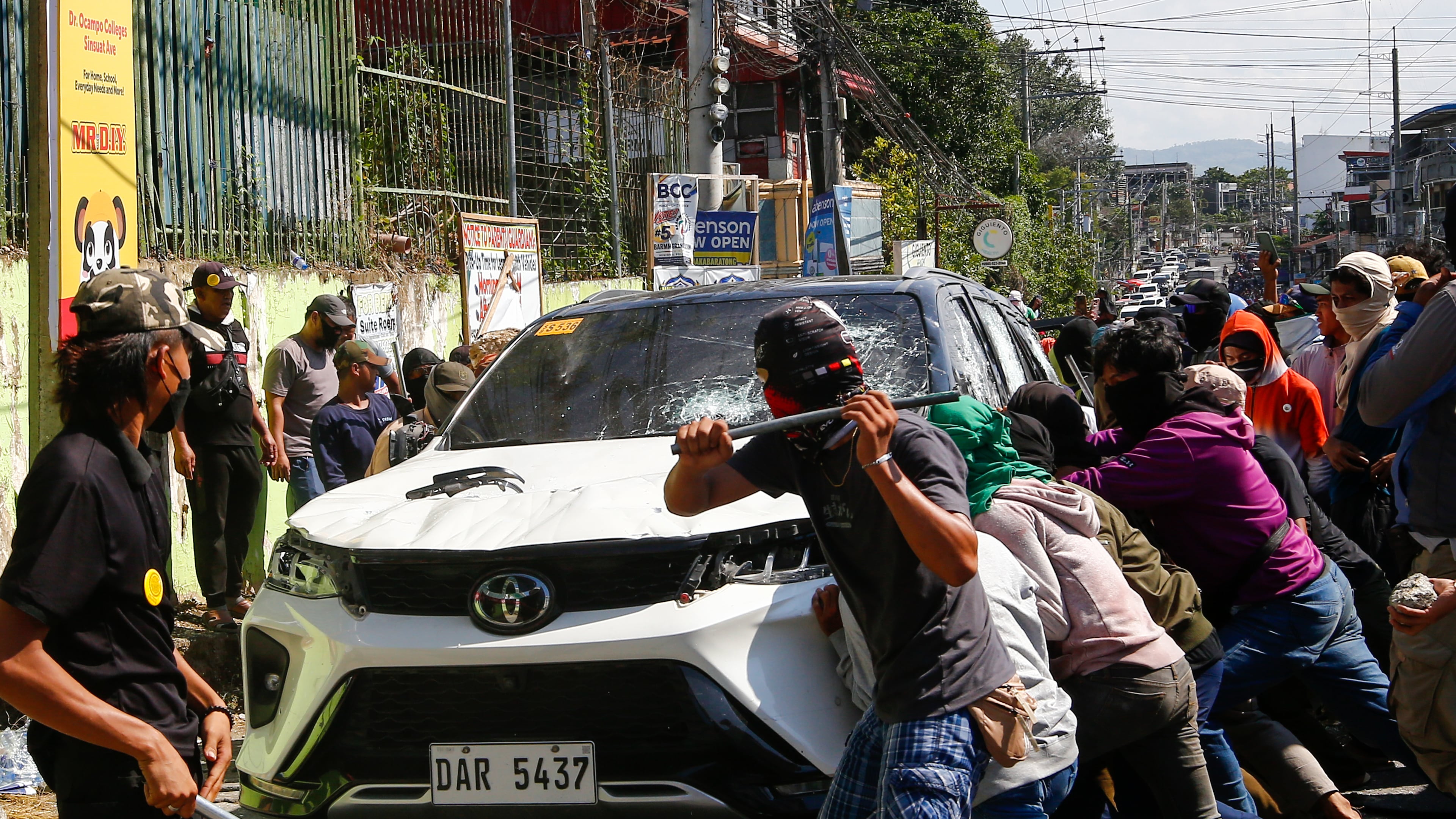 A group attacks a vehicle from an opposing group outside a school used as a polling center during the Bangsamoro Autonomous Region in Muslim Mindanao parliamentary elections in Cotabato city, southern Philippines, Monday, Sept. 14, 2026. (AP Photo)