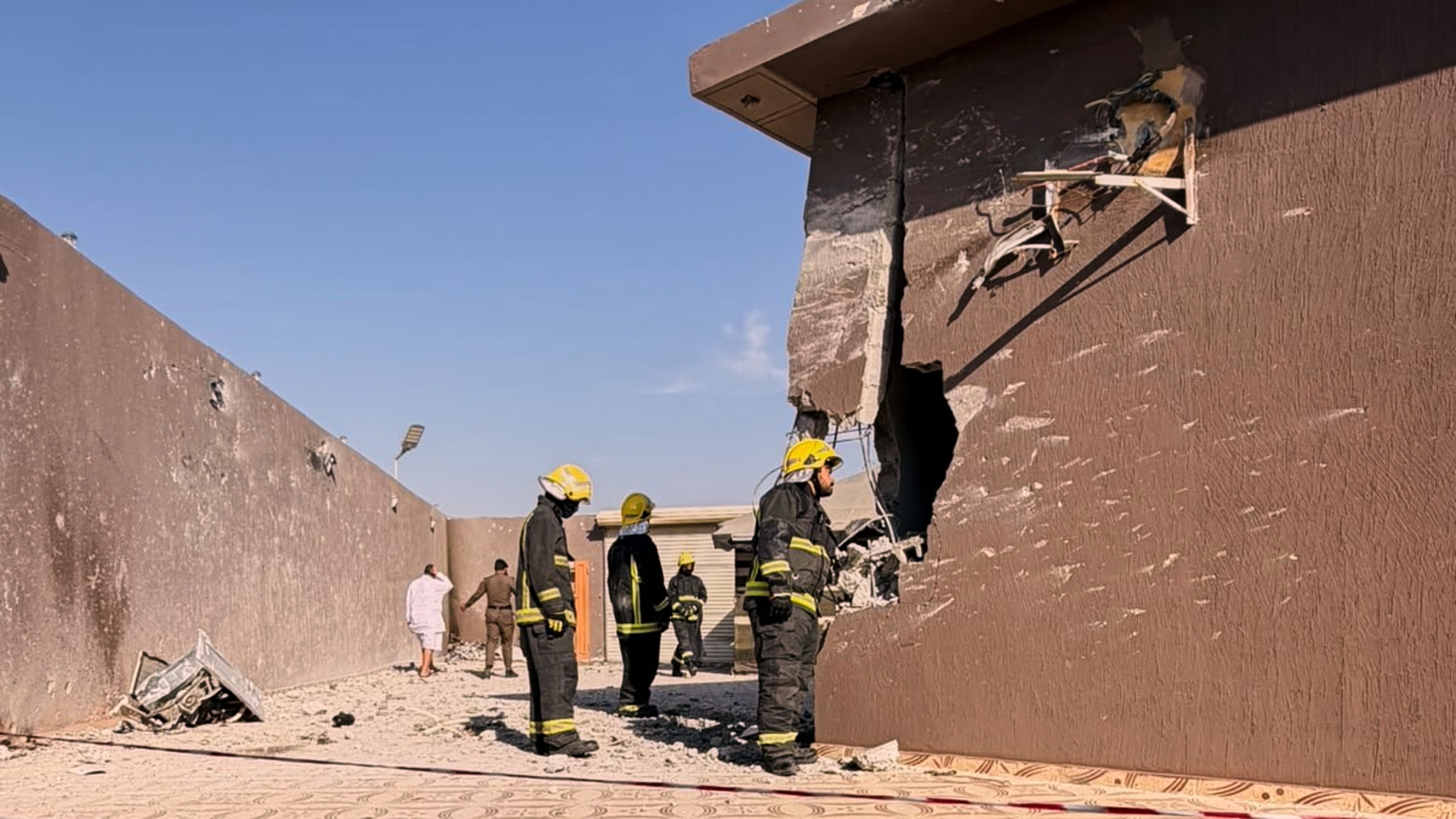 This photo provided by the Saudi Press Agency shows firefighters inspecting damage to a building caused by falling debris from a drone that Saudi authorities said was launched by Yemen's Houthi rebels and intercepted over Taif province, western Saudi Arabia, Thursday, Sept. 17, 2026. (Saudi Press Agency via AP)