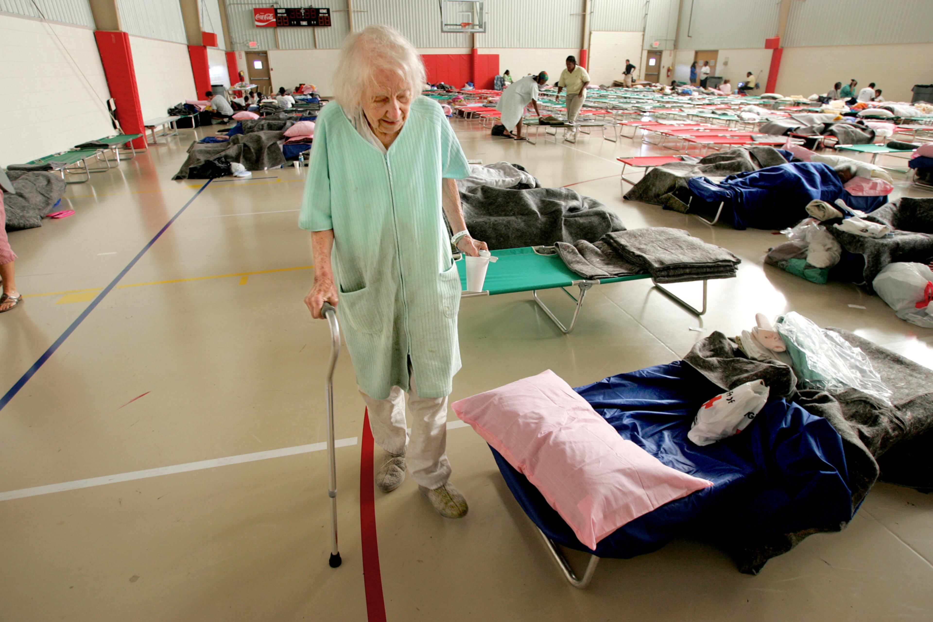 050902- COBB COUNTY - New Orleans refugee, Lillian Heinrich (CQ) makes her way from her cot Friday morning after awaking from her first nights stay in Atlanta. Some 100 refugees from New Orleans began streaming into the Boots Ward Recreation Center in Cobb county Thursday where the American Red Cross has made a shelter for those fleeing the catastrophe. (JOHN SPINK/AJC staff)