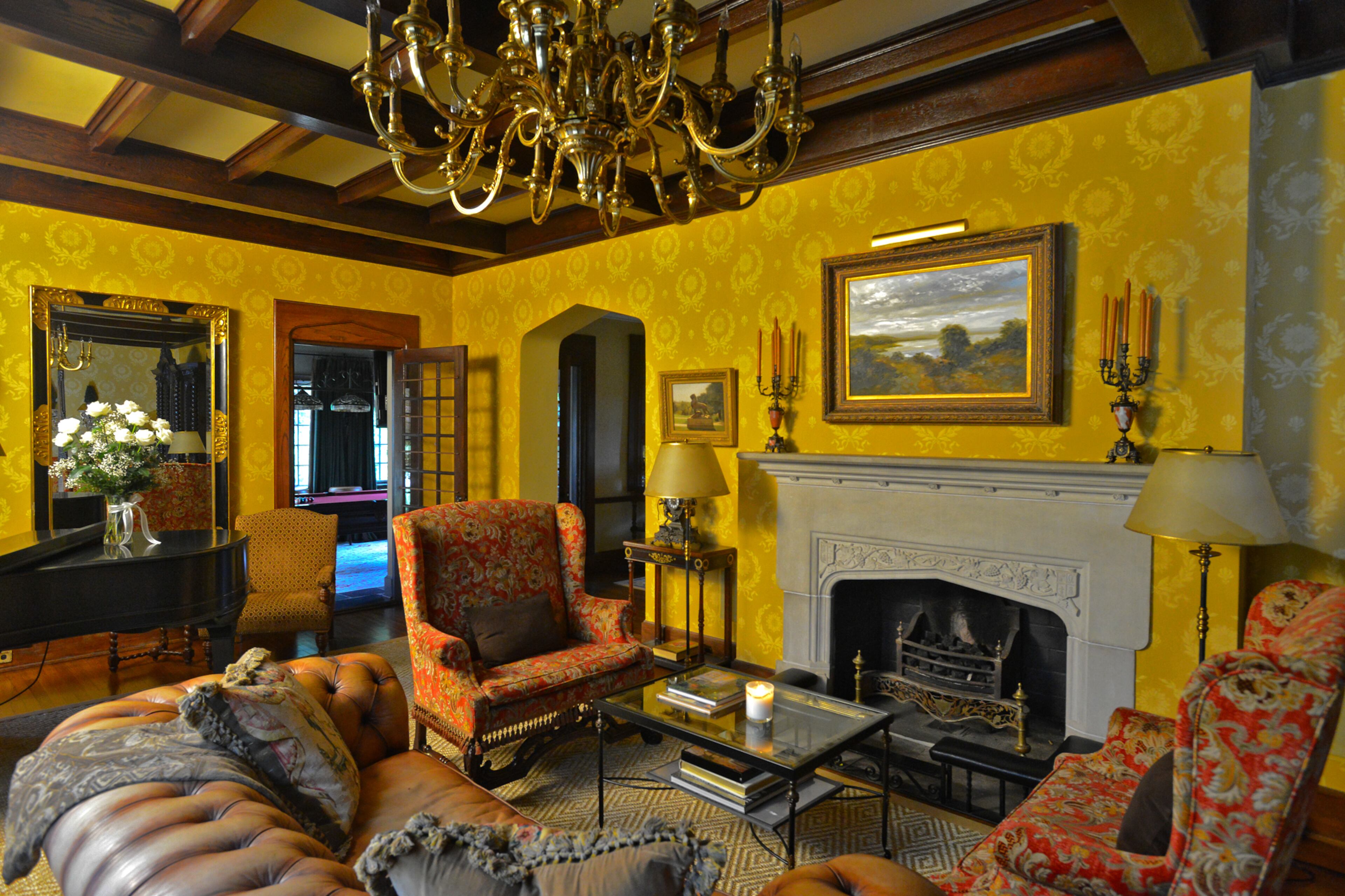 The walls in the formal living room are covered in ochre-colored wallcoverings by Zuber & Cie, a French manufacturer of painted wallpaper and fabrics. The fireplace is original to the home. Text by Lori Johnston and Keith Still/Fast Copy News Service