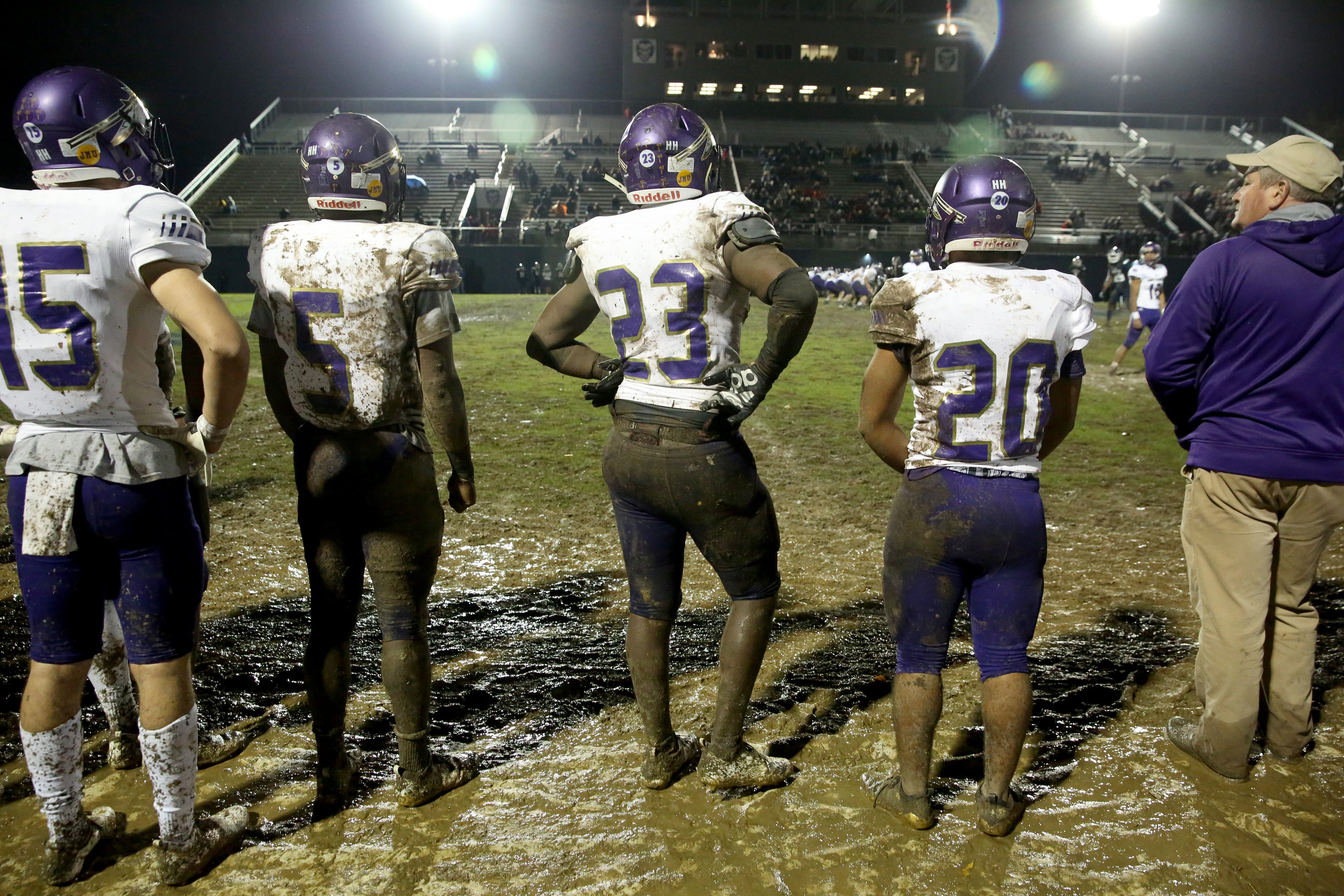 East Coweta players stand in the mud on the sideline at Marietta's Northcutt Stadium. (Jason Getz/Special)