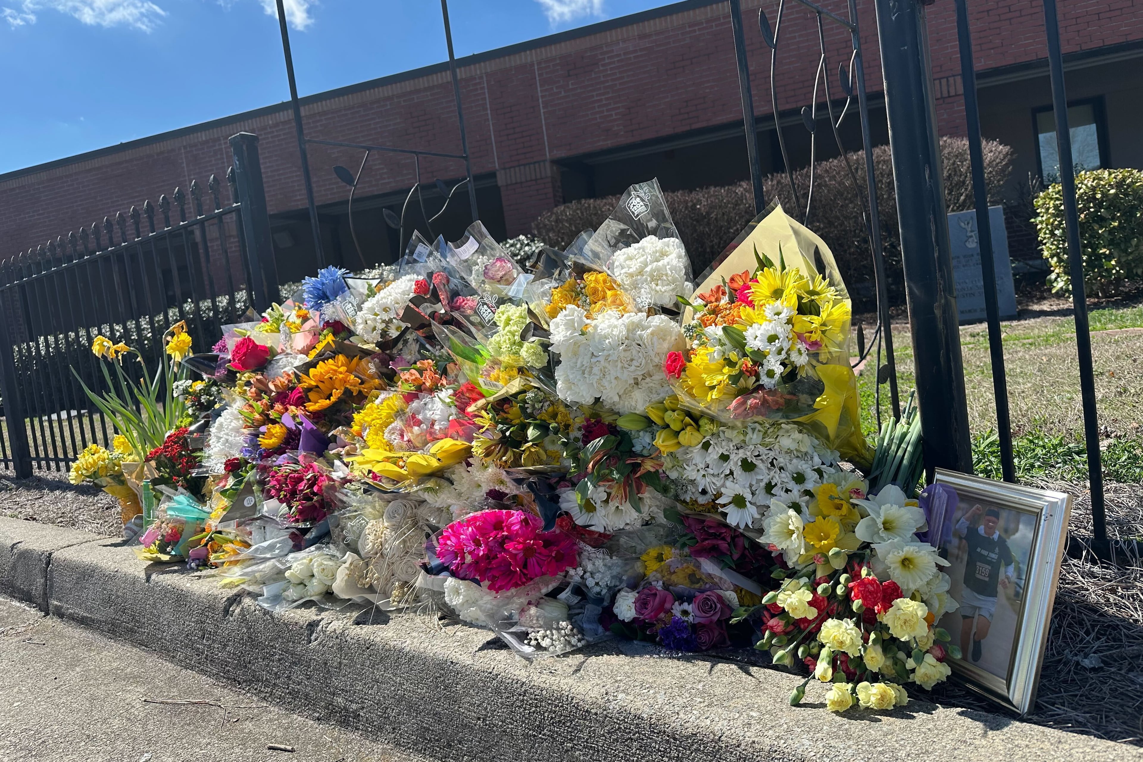 Flowers lie along a fence outside North Hall High School in Gainesville, Ga., on Monday, March 9, 2026. (Emilie Megnien/AP)
