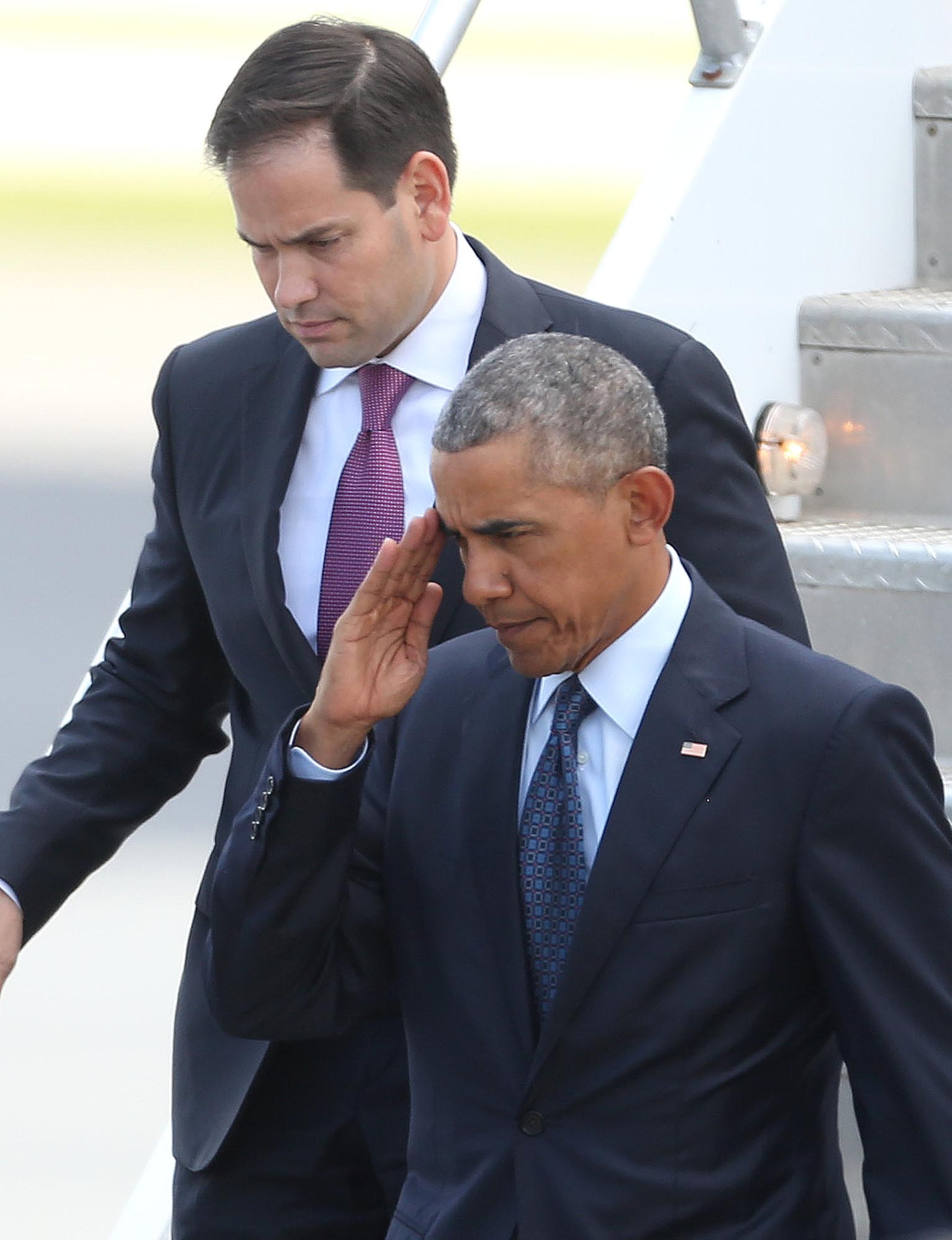 President Obama salutes in front of Florida Sen. Marco Rubio, top, after as the president deplanes after his arrival at Orlando International Airport, Thursday, June 16, 2016, in Orlando, Fla. Obama is in Orlando today to pay respects to the victims of the Pulse nightclub shooting and meet with families of victims of the attack. (Stephen M. Dowell/Orlando Sentinel via AP)