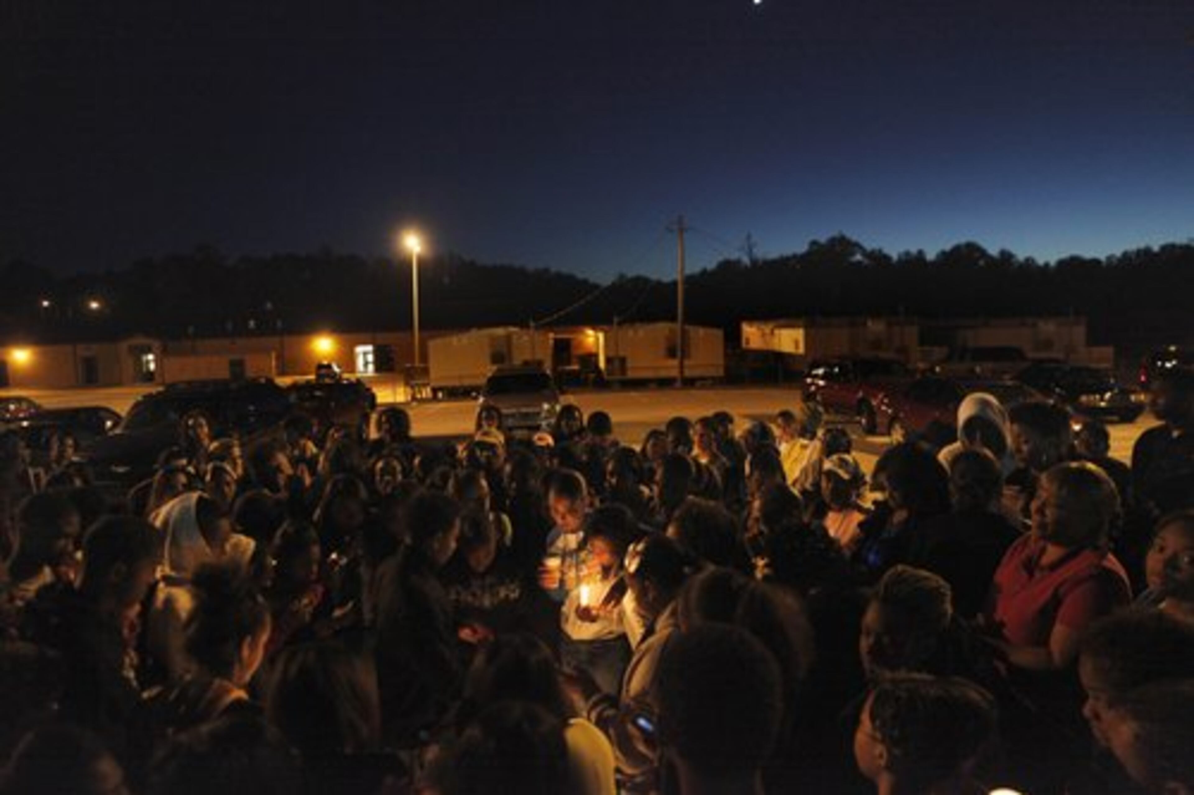 Fashionee Jones, 15, center, the sister of Bobby Tillman, is surrounded by his friends and classmates during vigil.