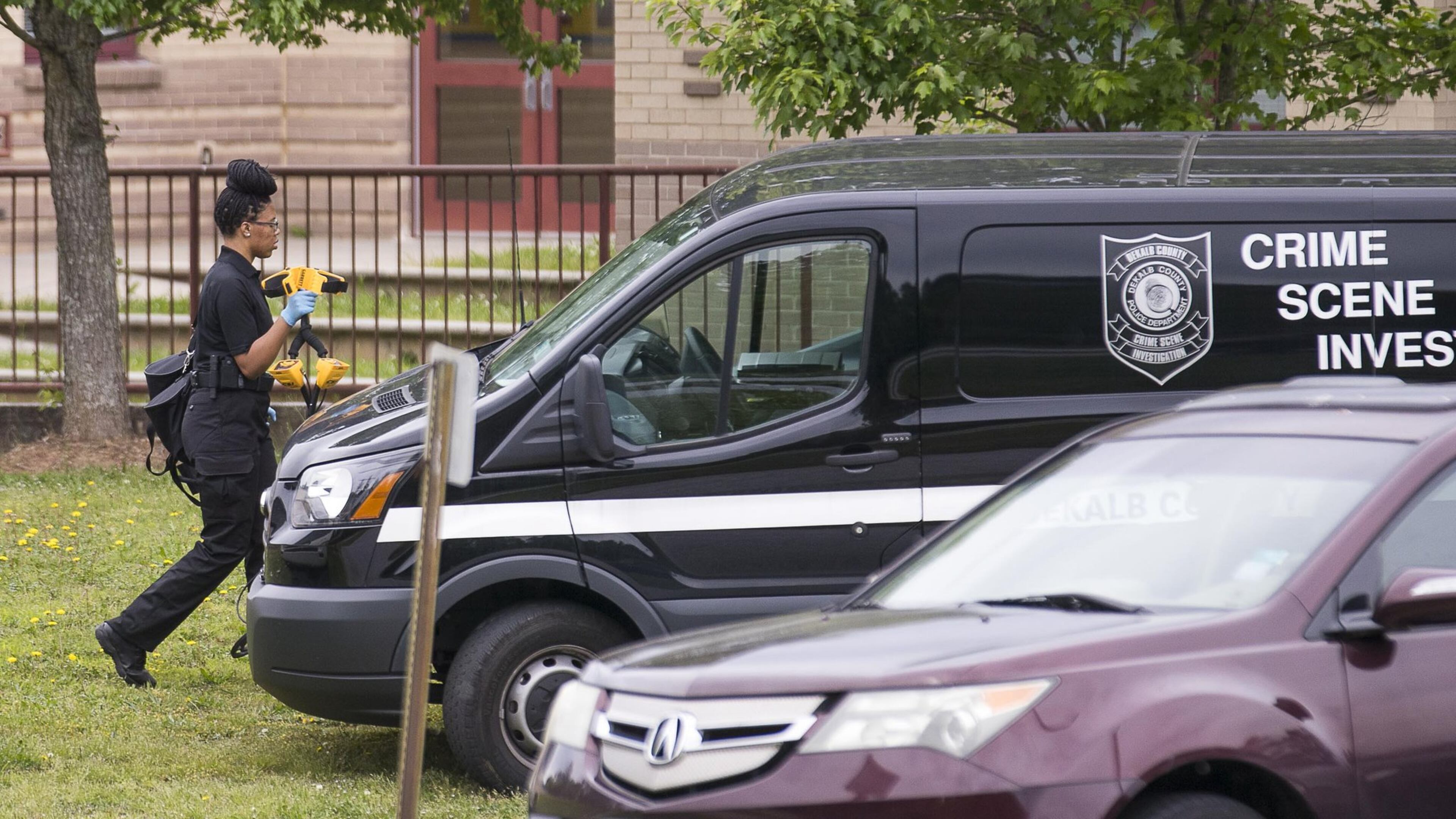 A DeKalb County Crime Scene Investigator carries her tools back to her vehicle outside of Wynbrooke Elementary School in Stone Mountain, Thursday, April 25, 2019. ALYSSA POINTER/ALYSSA.POINTER@AJC.COM