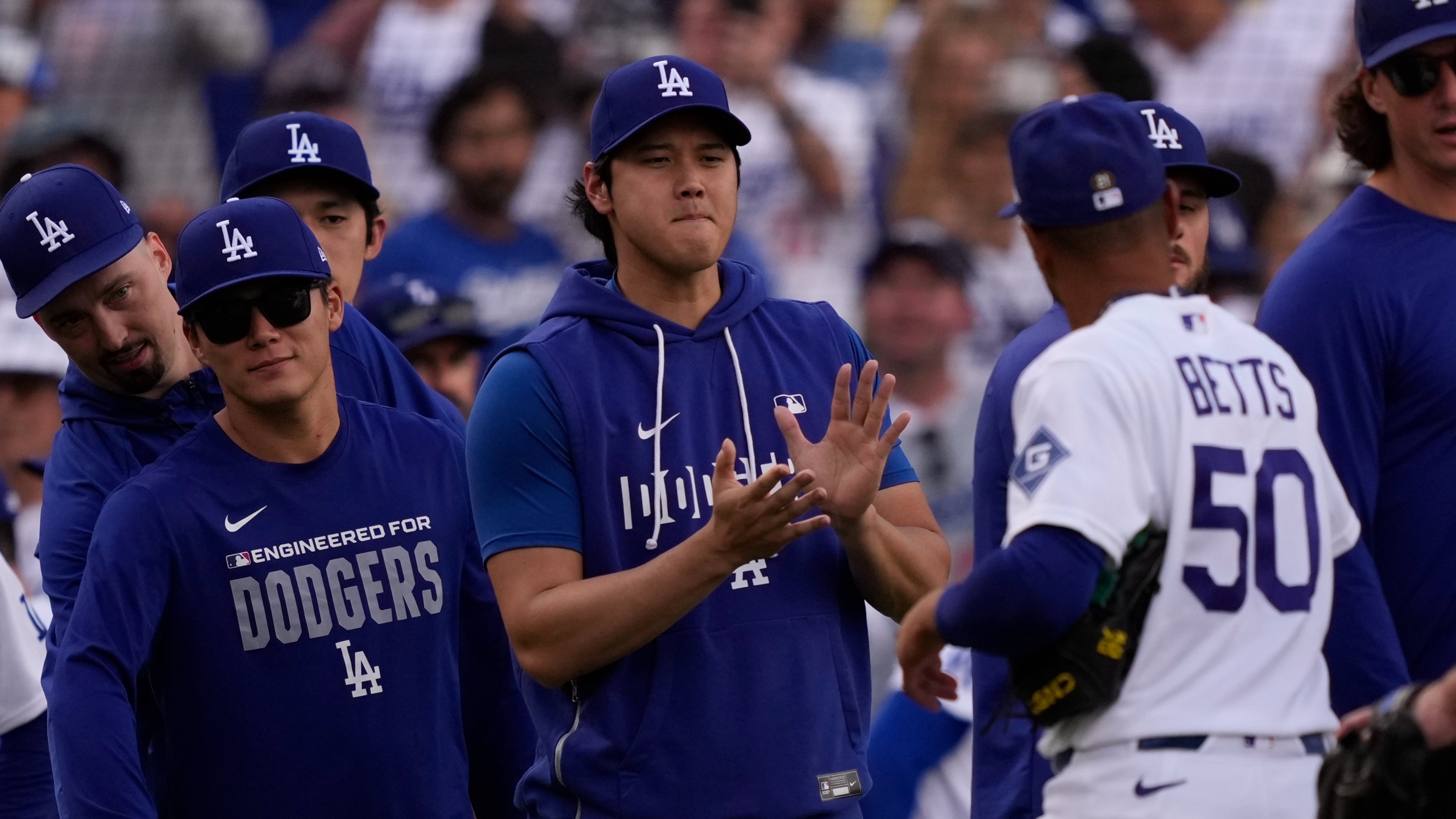 Los Angeles Dodgers' Mookie Betts, right, is congratulated by Shohei Ohtani, center, and Yoshinobu Yamamoto after the Dodgers defeated the San Francisco Giants in a baseball game Sunday, Sept. 20, 2026, in Los Angeles. (AP Photo/Mark J. Terrill)