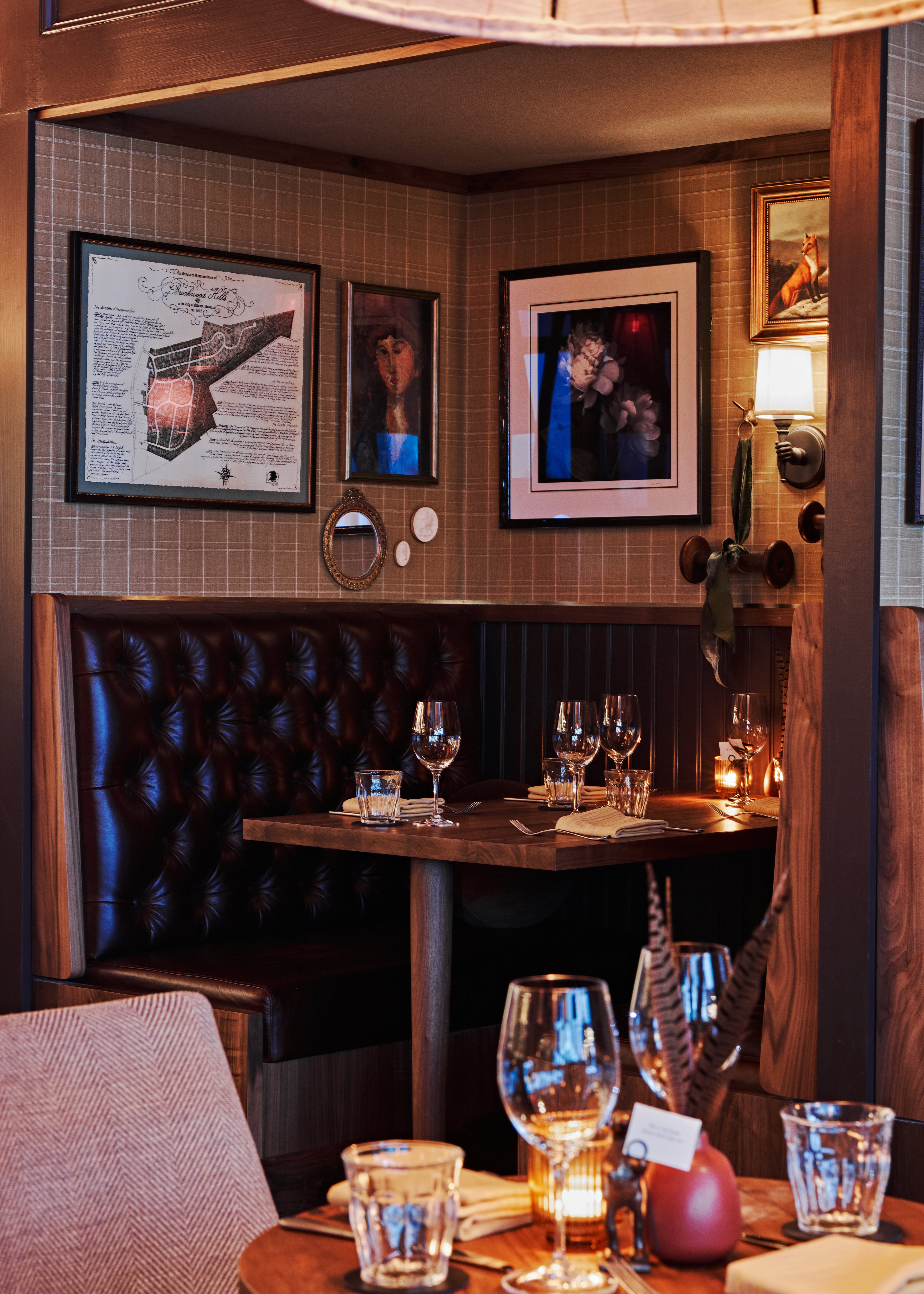 One of the booths at Holeman & Finch features a map of Brookwood Hills, the restaurant's former neighborhood. Also in this booth are two floral photographs from Lynne Harty, a photographer from Asheville, whose work also hangs in the Holeman & Finch in Asheville. / Courtesy of Holeman & Finch