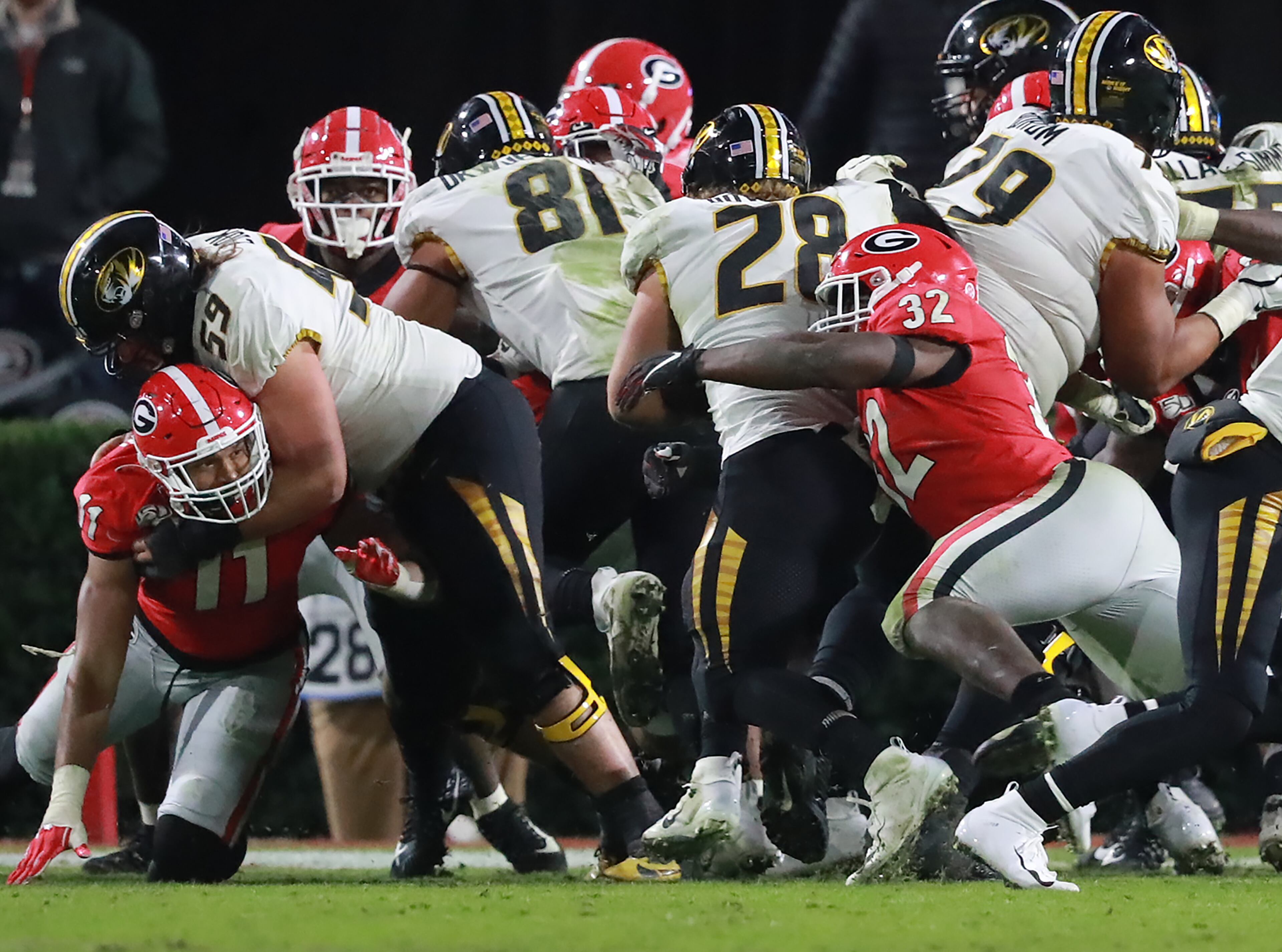 Georgia inside linebacker Monty Rice (right) tackles Missouri running back Dawson Downing for a loss of yardage on a second down attempt during a goal line stand to help keep Missouri out of the end zone on four attempts to preserve a 27-0 shutout during the final minutes of the fourth quarter in a NCAA college football game on Saturday, November 9, 2019, in Athens. Curtis Compton/ccompton@ajc.com