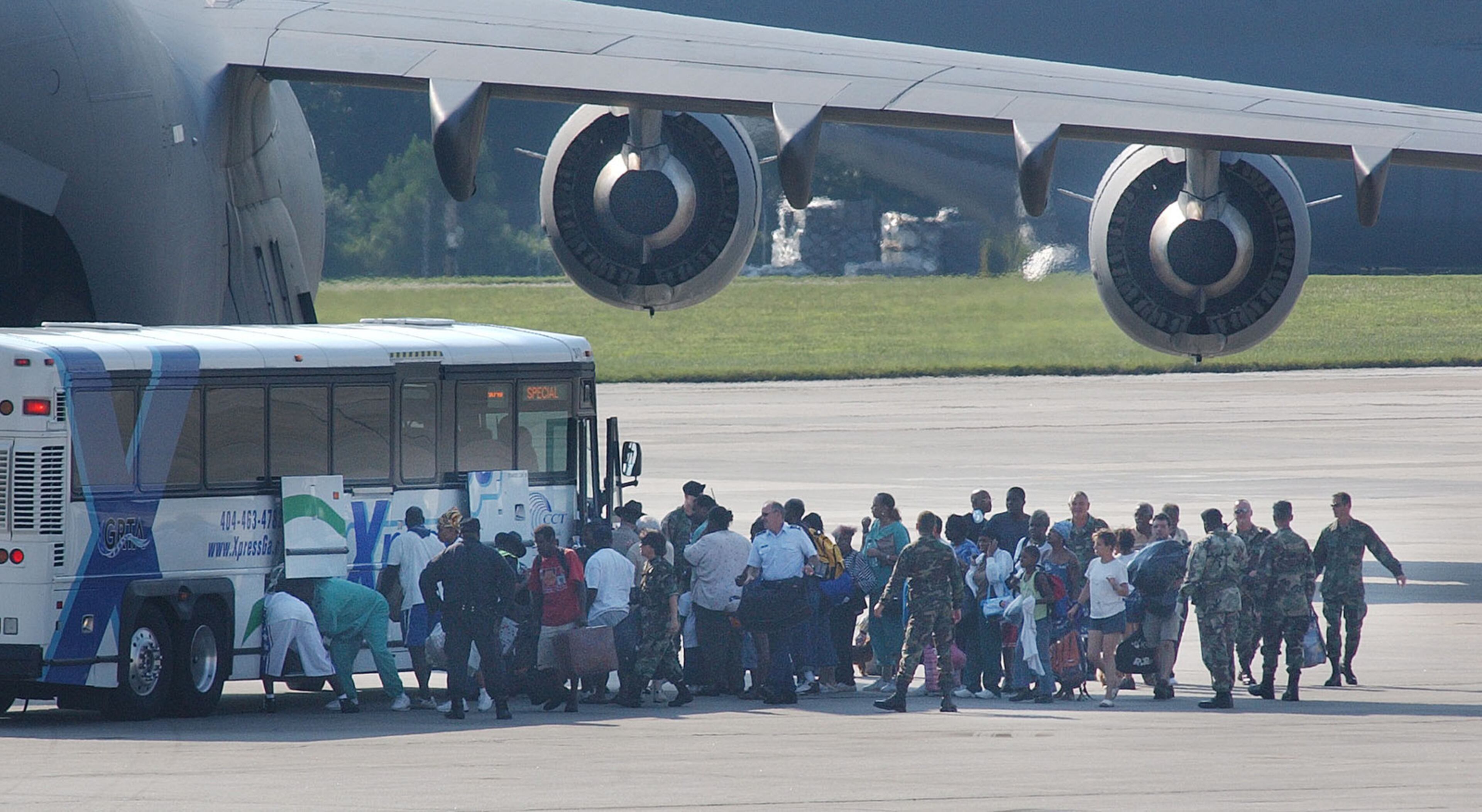 0500901 MARIETTA, GA (cobb): In a Thursday 9/1/05 photo a group of Hurricane Katrina evacuees arrive from New Orleans on a military transport plane at Dobbins Air Reserve Base around 5pm today. Several other planes were to arrive throughout the night, some of the planes carrying people in need of medical assistance (we were not allowed to photograph these planes coming in). PHOTO BY ANDY SHARP/STAFF.