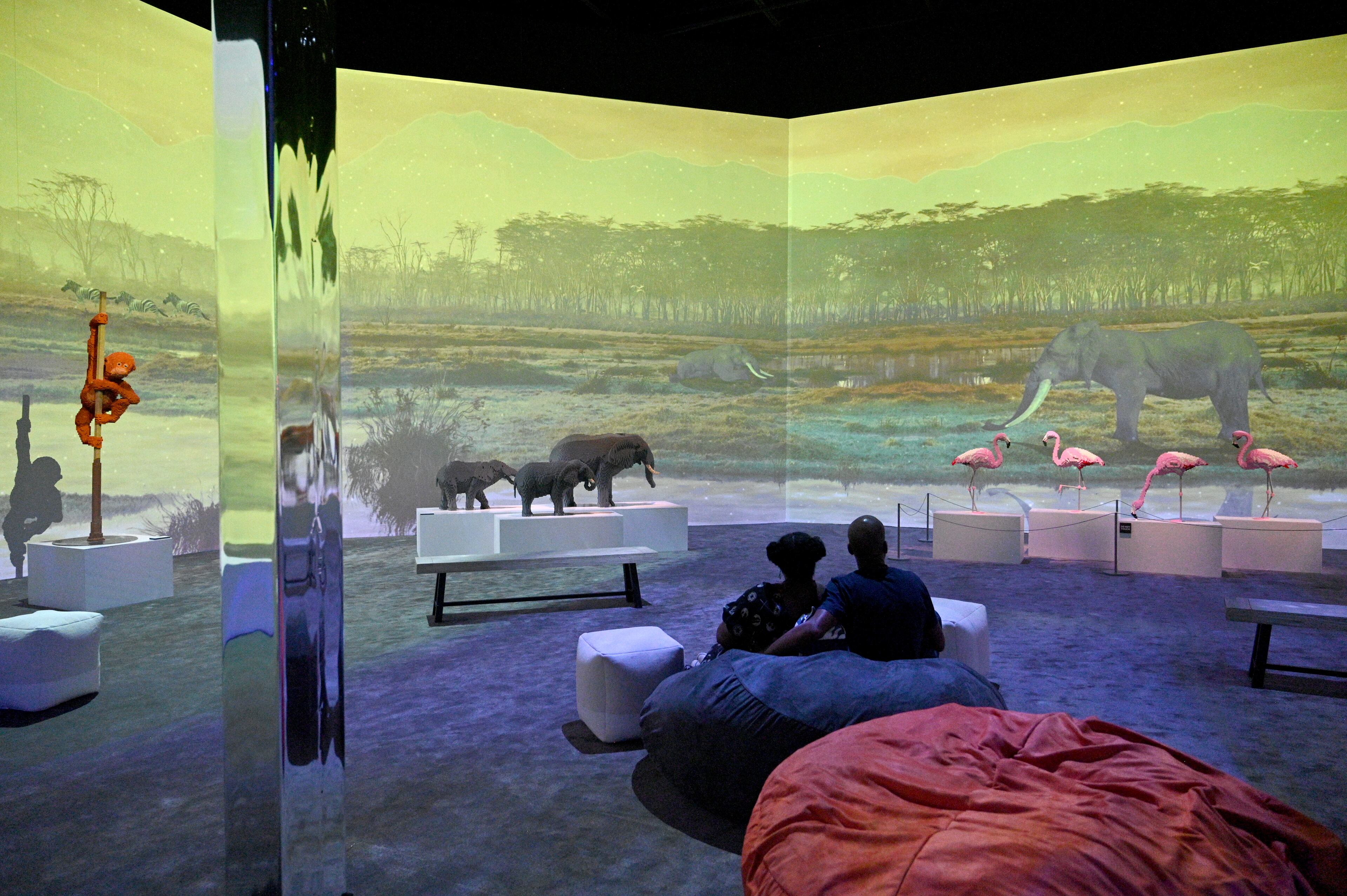 Visitors enjoy Lego sculptures in “Perniciem” room at "Art of the Brick Immersive Experience" exhibition at Exhibition Hub Atlanta Art Centre, Wednesday, April 19, 2023, in Doraville. The exhibition will feature many pieces and themes, including a room with oversized sculptures (25-foot long), over 70 works of art crafted from more than 1 million LEGO bricks, galleries celebrating human-kind and nature, and a short documentary about how Nathan creates his works. (Hyosub Shin / Hyosub.Shin@ajc.com)