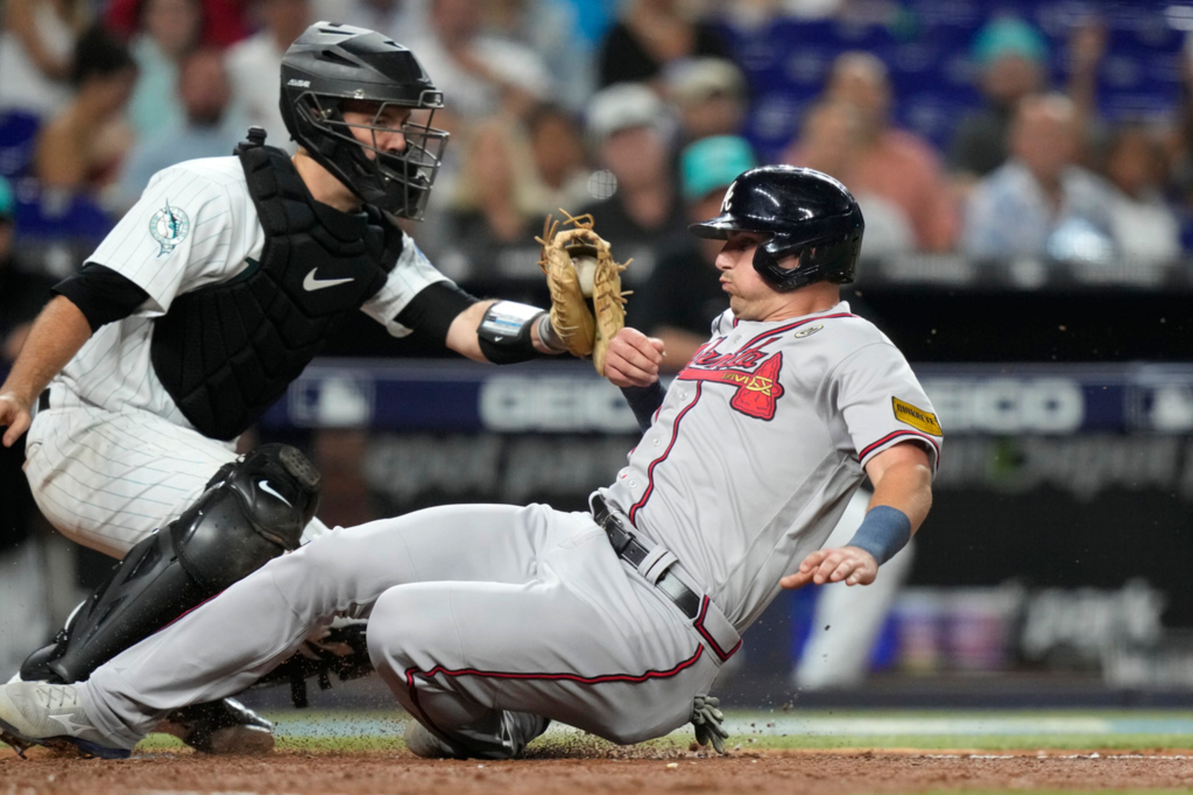 Atlanta Braves' Austin Riley, right, beats the throw to Miami Marlins catcher Jacob Stallings to score during the fifth inning of a baseball game Friday, Sept. 15, 2023, in Miami. (AP Photo/Lynne Sladky)