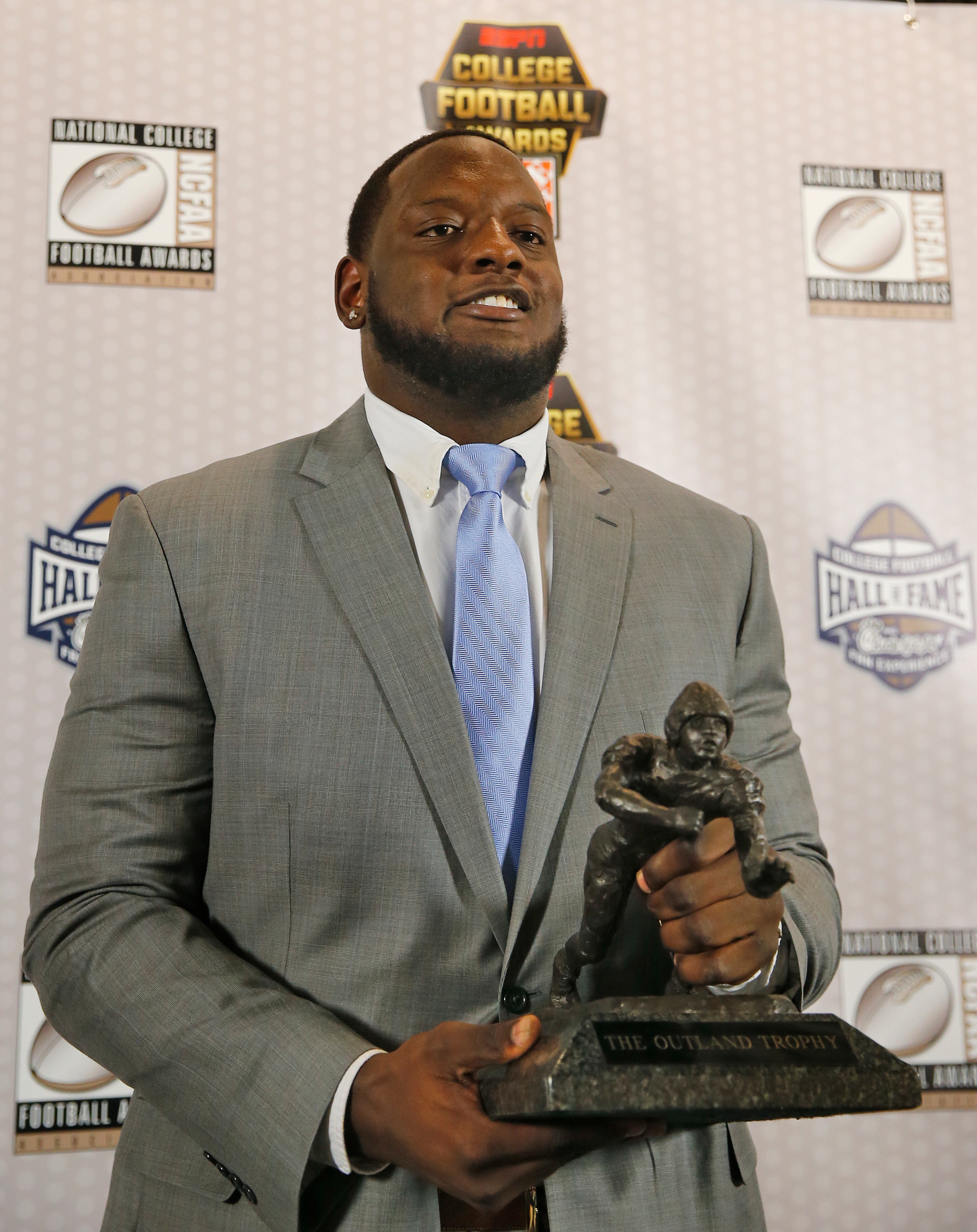Alabama lineman Cam Robinson holds the Outland Trophy after being named college football's most outstanding interior lineman Thursday, Dec. 8, 2016, in Atlanta. (AP Photo/John Bazemore)
