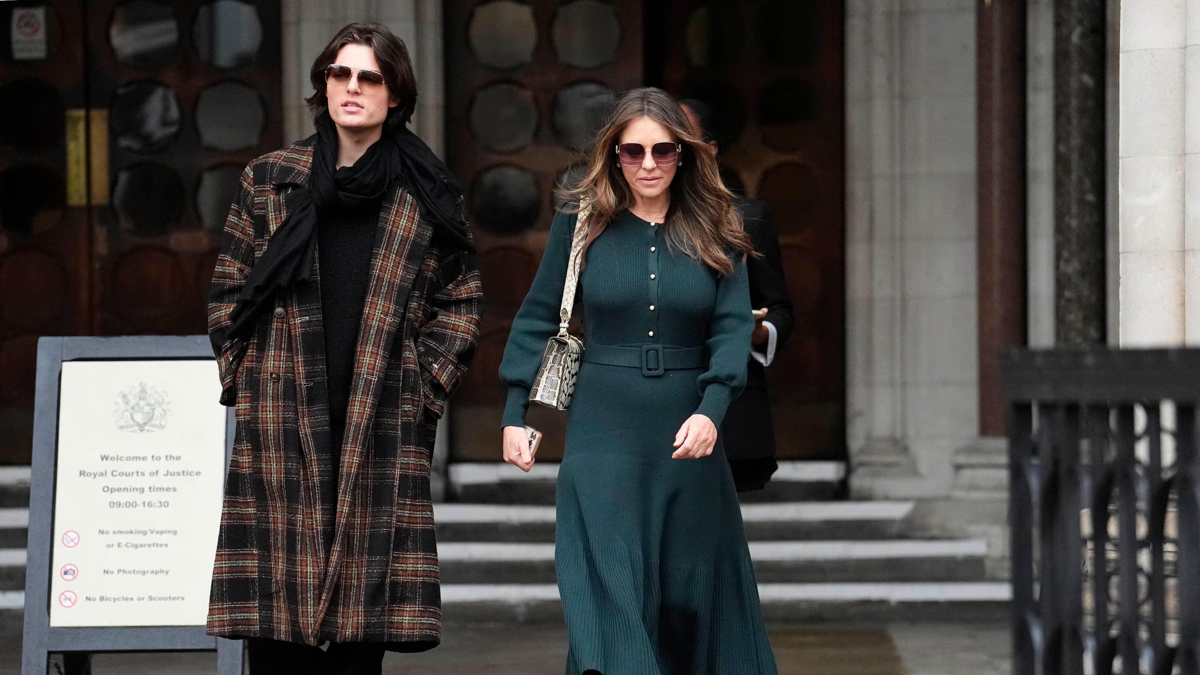 Elizabeth Hurley, right, leaves the Royal Courts of Justice on day four of the trial over allegations of unlawful information gathering brought against Associated Newspapers Limited, Thursday, Jan. 22, 2026, in London. (Jordan Pettitt/PA via AP)