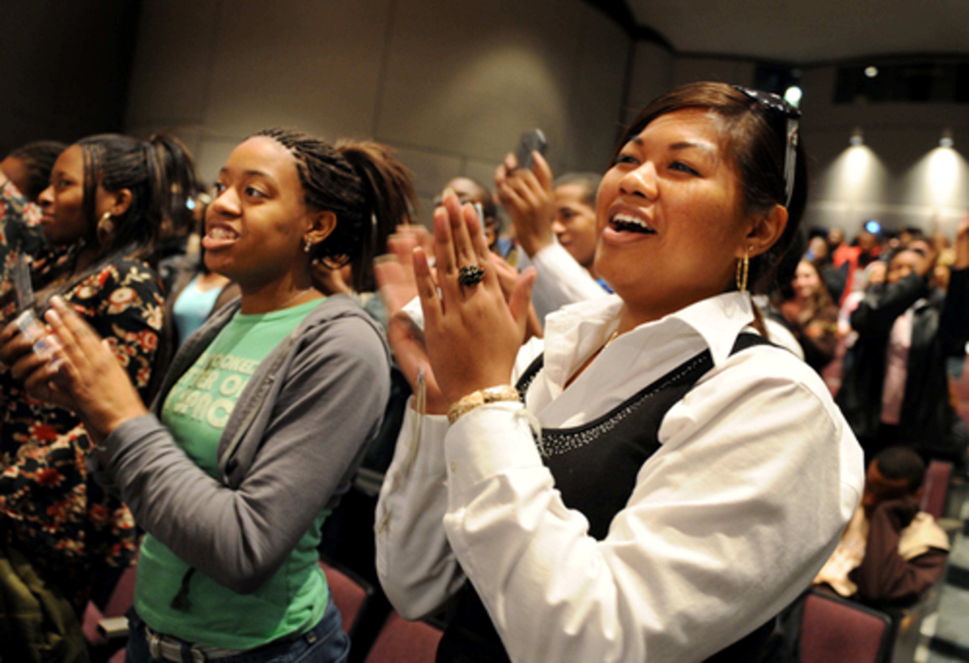 Lina Chhem (right) and Brionna June, students at North Clayton High School, cheer Stone at the end of her performance.