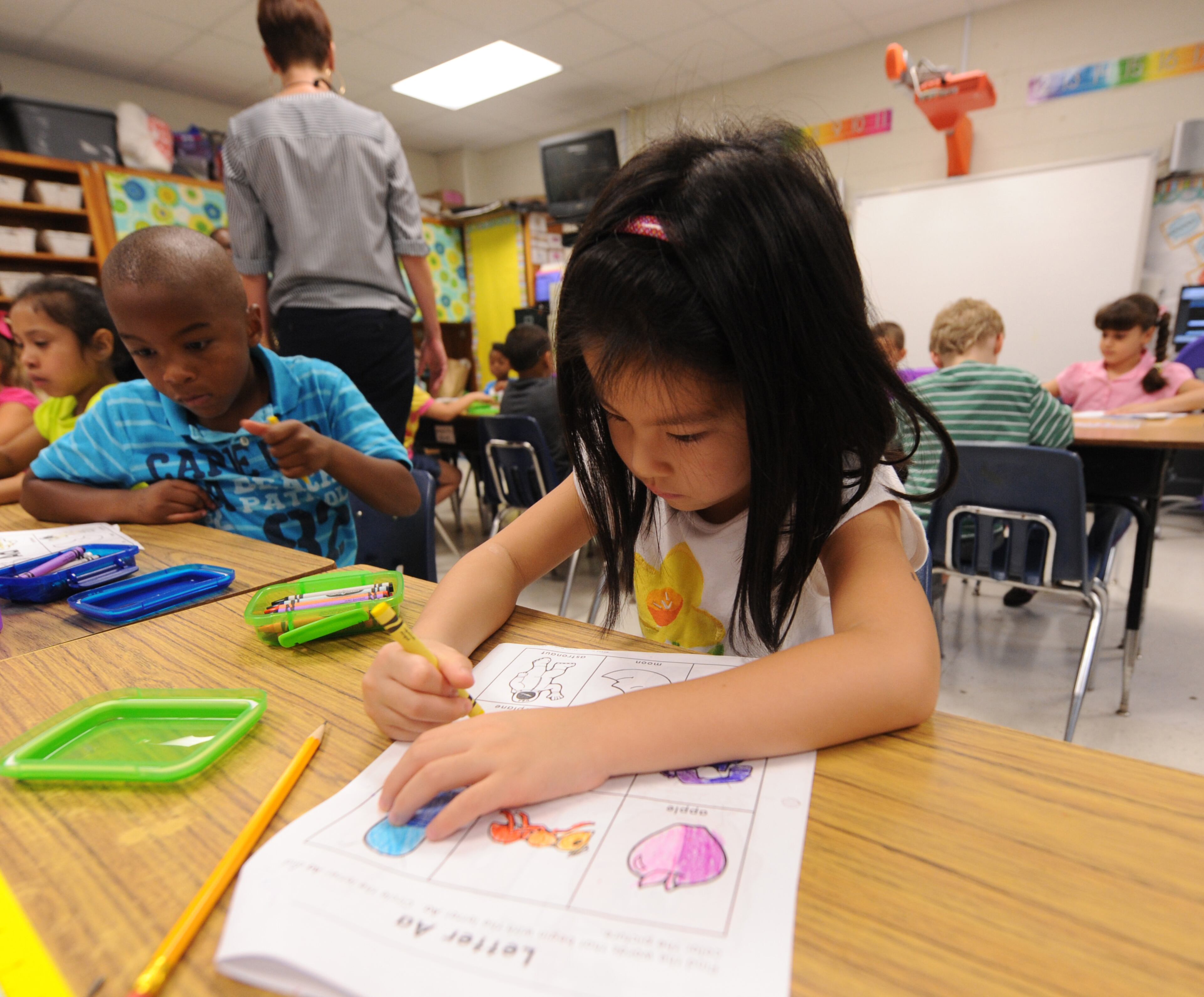Audrey Hu works on her first assignment in first grade at Midvale Elementary on Monday, August 12, 2013. DeKalb County schools started school today. JOHNNY CRAWFORD / JCRAWFORD@AJC.COM