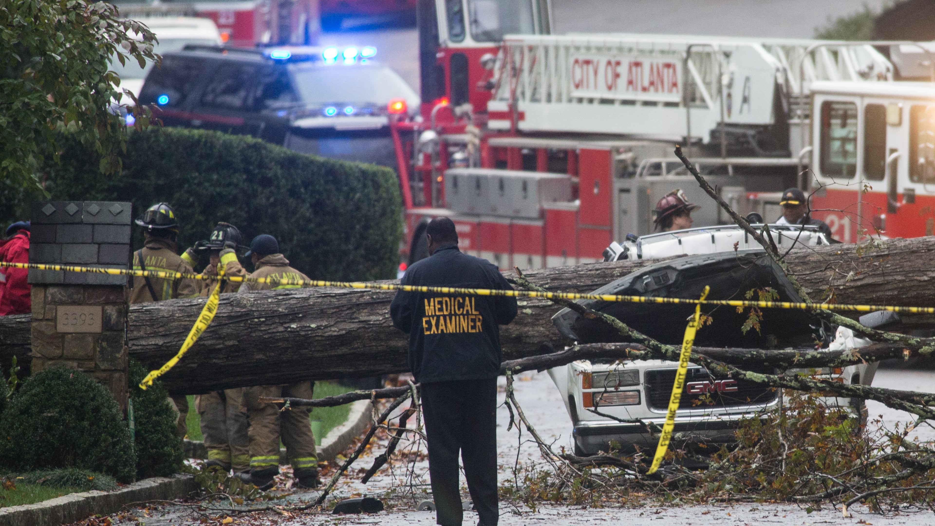 A medical examiner and Atlanta firefighters work a scene where a driver was killed after he drove his vehicle into a tree that fell on Woodhaven Road in Buckhead, Monday, Nov. 9, 2015. BRANDEN CAMP/SPECIAL