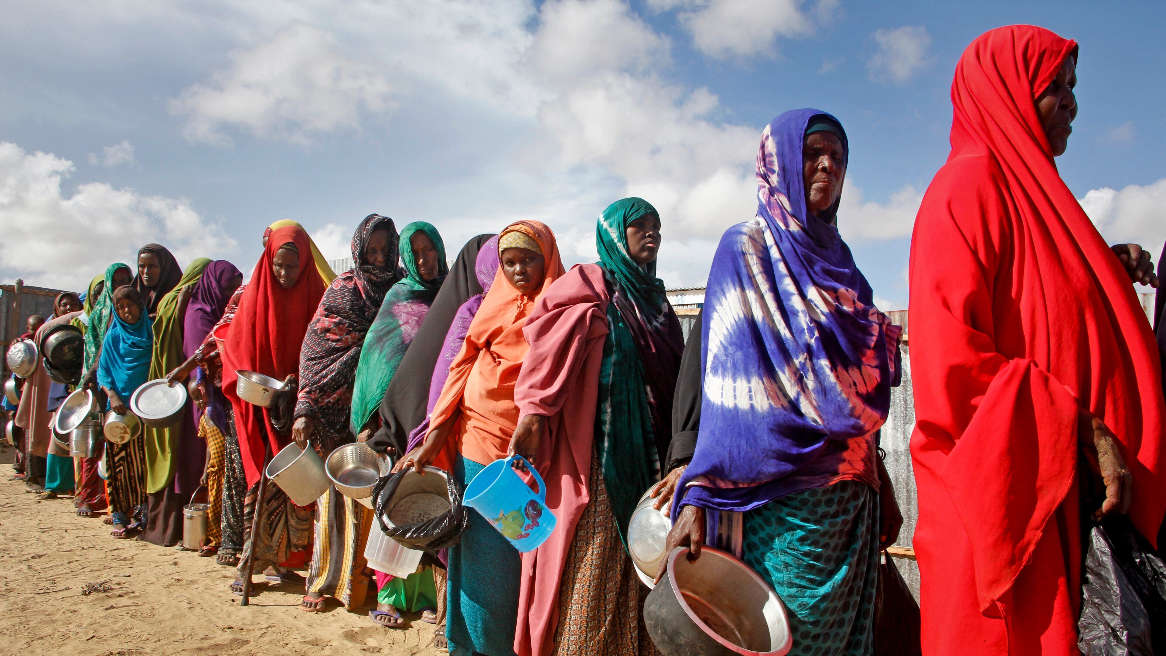FILE - In this May 18, 2019 file photo, newly-arrived women who fled drought line up to receive food distributed by local volunteers at a camp for displaced persons in the Daynile neighborhood on the outskirts of the Somalian capital Mogadishu. (AP Photo/Farah Abdi Warsameh, file)