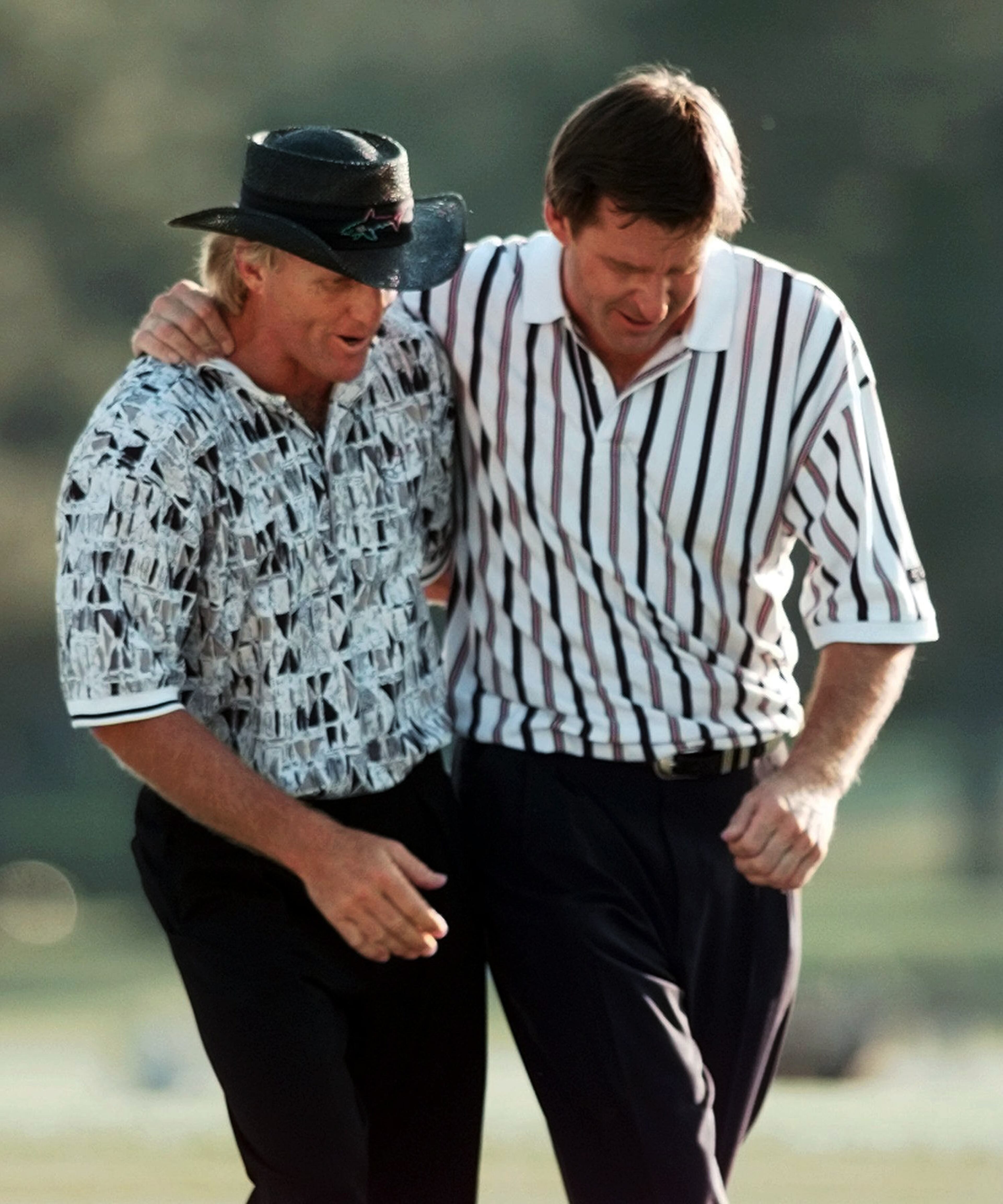 GREG NORMAN: In this April 14, 1996, file photo, England's Nick Faldo, right, and Australia's Greg Norman walk off the 18th hole after Faldo won his third Masters golf tournament at the Augusta National Golf Club in Augusta, Ga. Norman, who has won every major but the Masters, is most famous for his collapse in 1996, the year he tied the course record with a 63 in the opening round but could not hold hold off Faldo when it counted on Sunday. (AP Photo/Dave Martin, File)