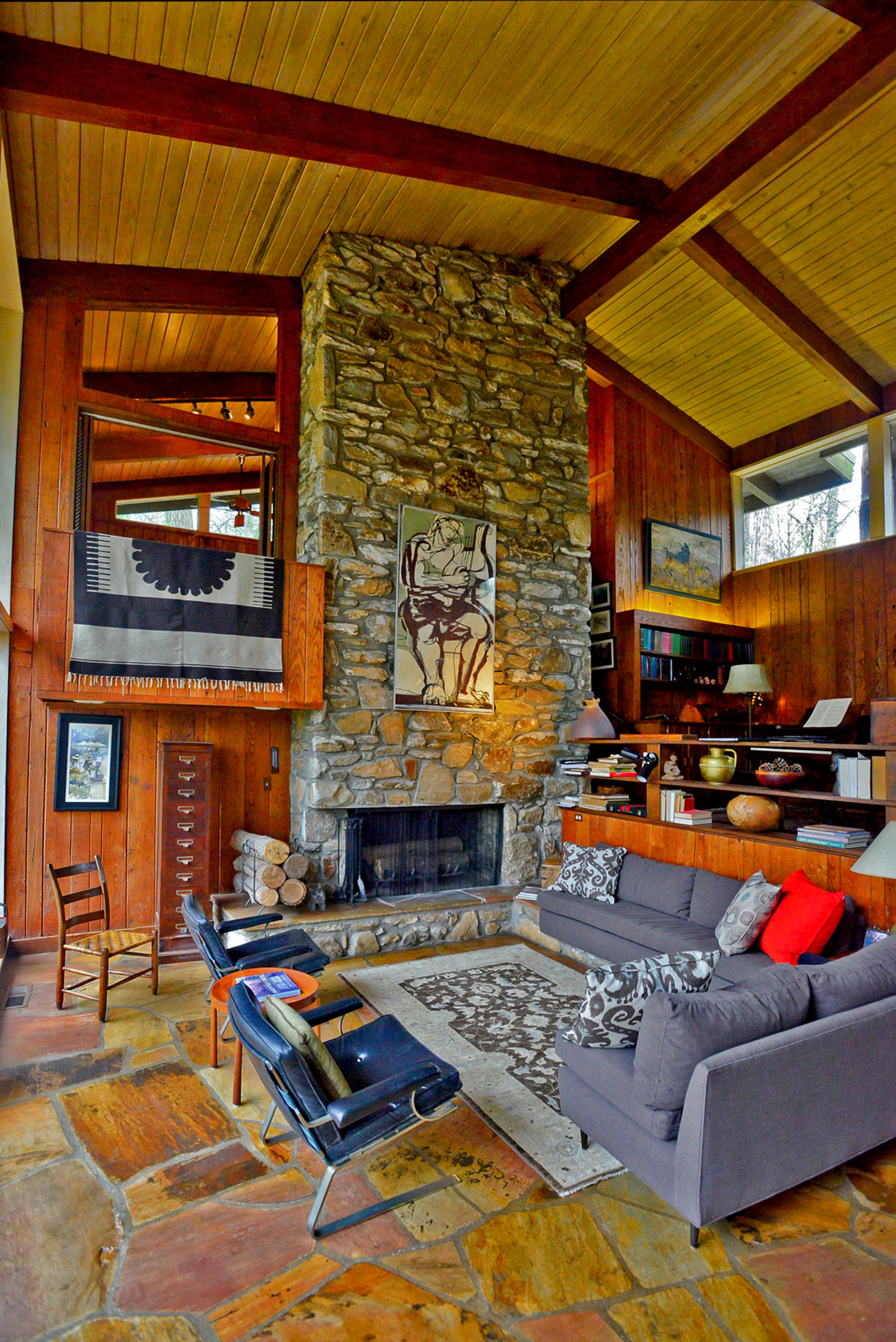 Floors made of crab orchard stone from Tennessee ground the living area and its beamed, vaulted yellow pine ceiling. The 22-foot fireplace is made from stone from north Georgia and the walls are made of wormy chestnut.