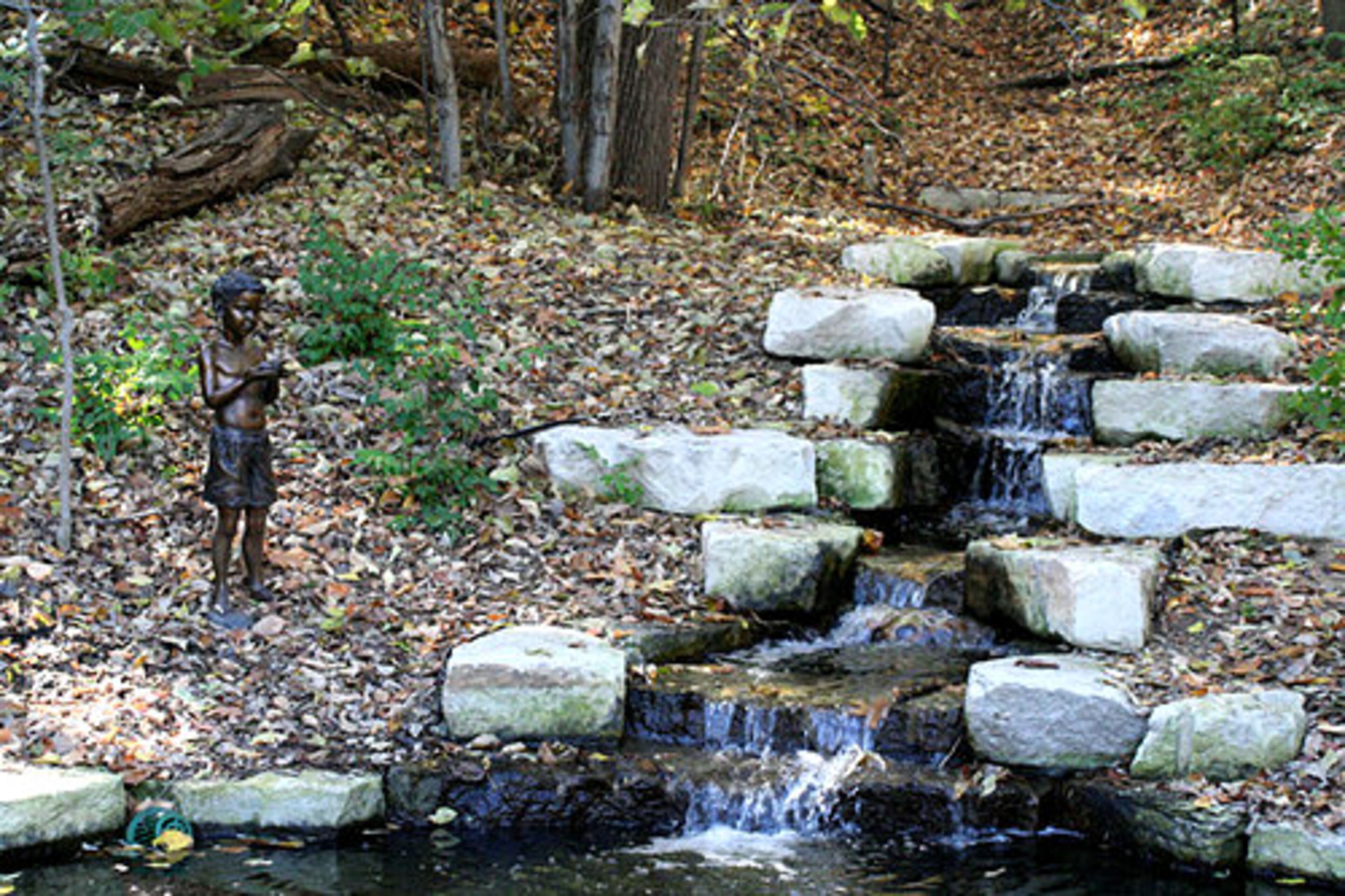Tucked among Lauritzen Gardens' more formal plantings are little oases like this, featuring a stream and a statue.
