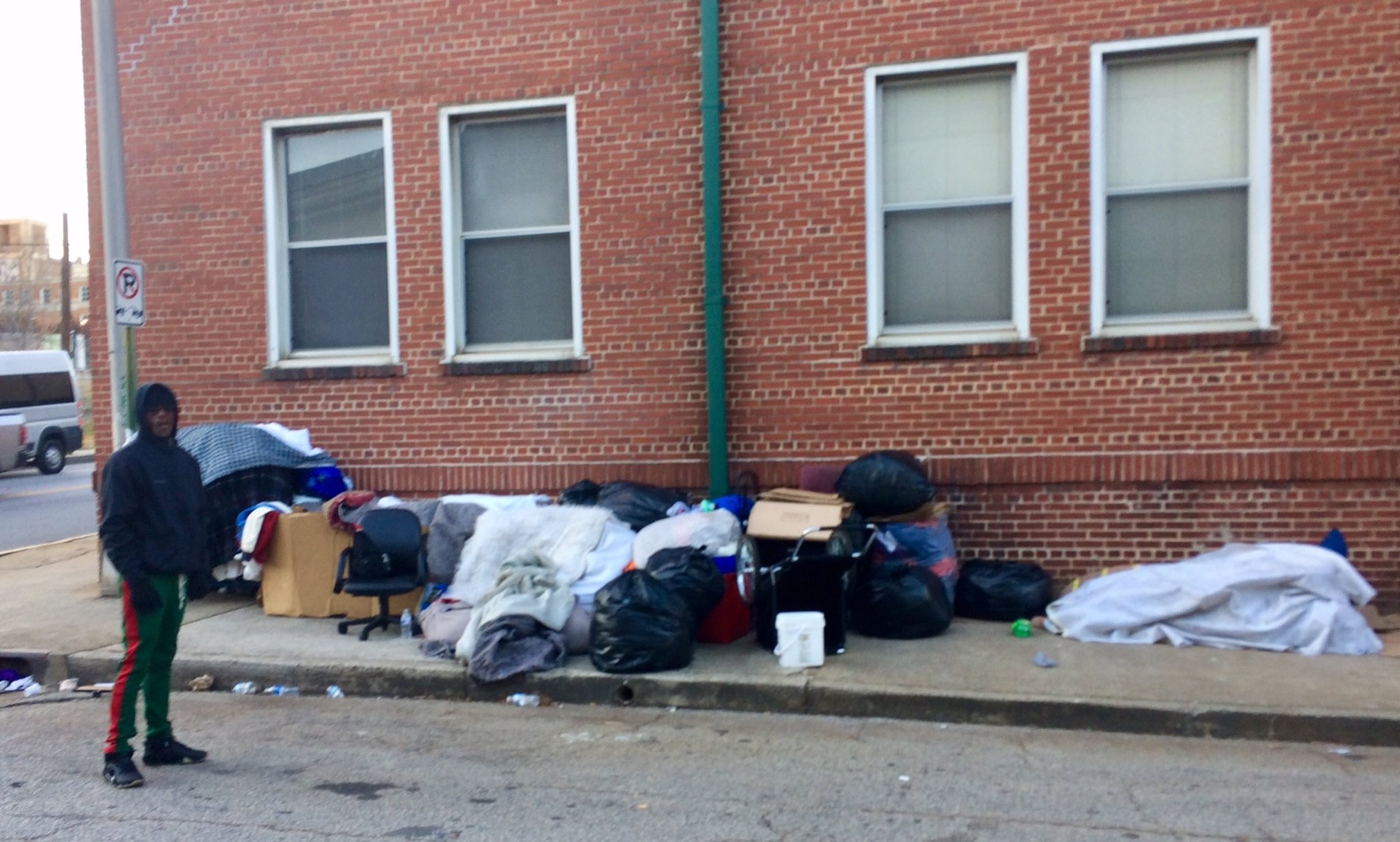 Will Woods stands near a mountain of belongings owned by him and other homeless men who camp out under the tunnel near Grady Memorial Hospital in Atlanta.