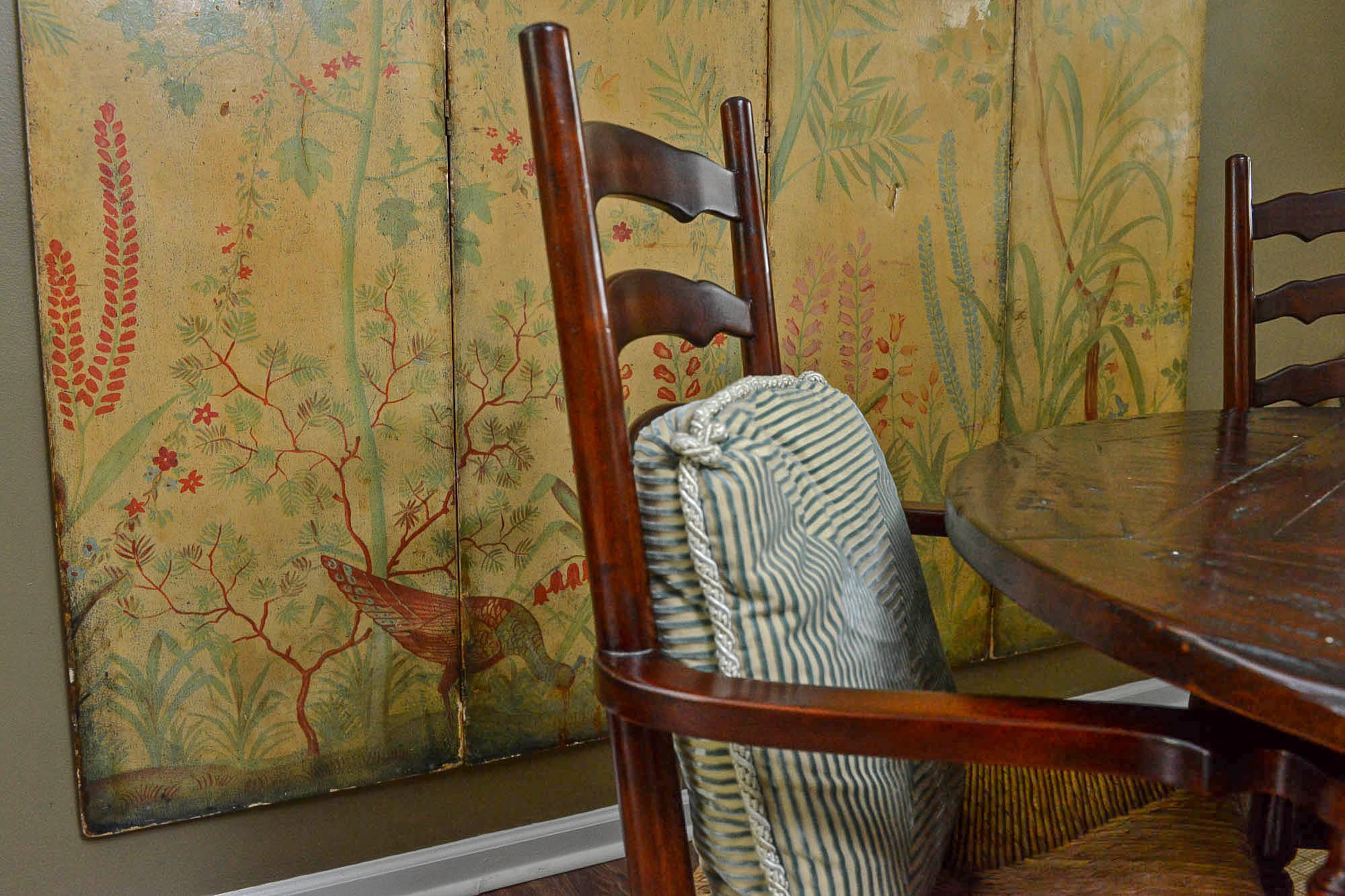 The screen, which features flora and a bird, was found at a local estate sale and intended for a bedroom. "I was going to use it first as a headboard but after playing around, realized mounting it as art was the perfect solution to fill the space and show off the hand-painted screen," she said.