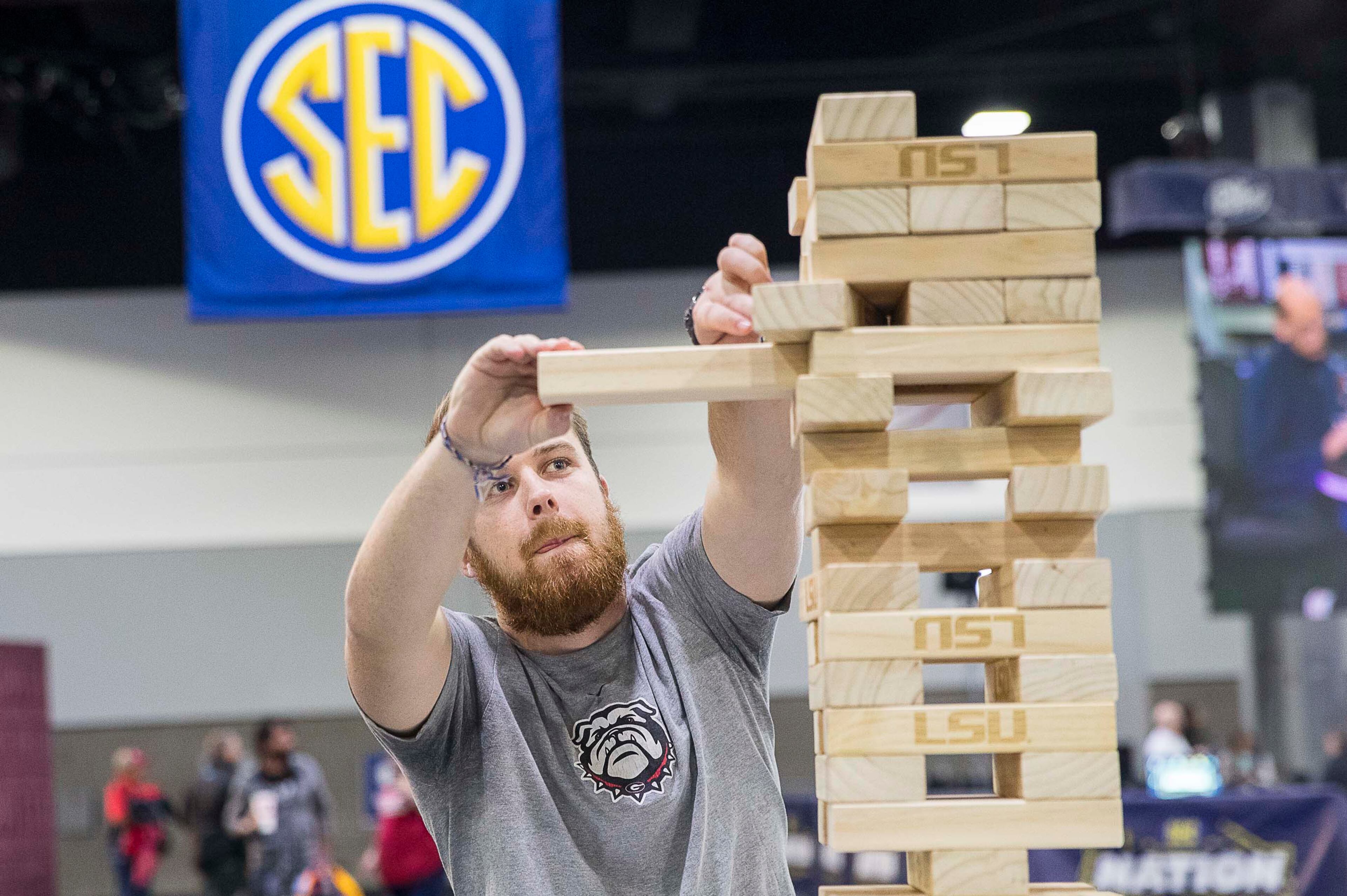 University of Georgia Bulldogs Fan Luke Orange, of Marietta, slowly pulls a block while playing a stacking game at the SEC Fan Fare experience at the Georgia World Congress Center in Atlanta, Friday, December 6, 2019. (ALYSSA POINTER/ALYSSA.POINTER@AJC.COM)