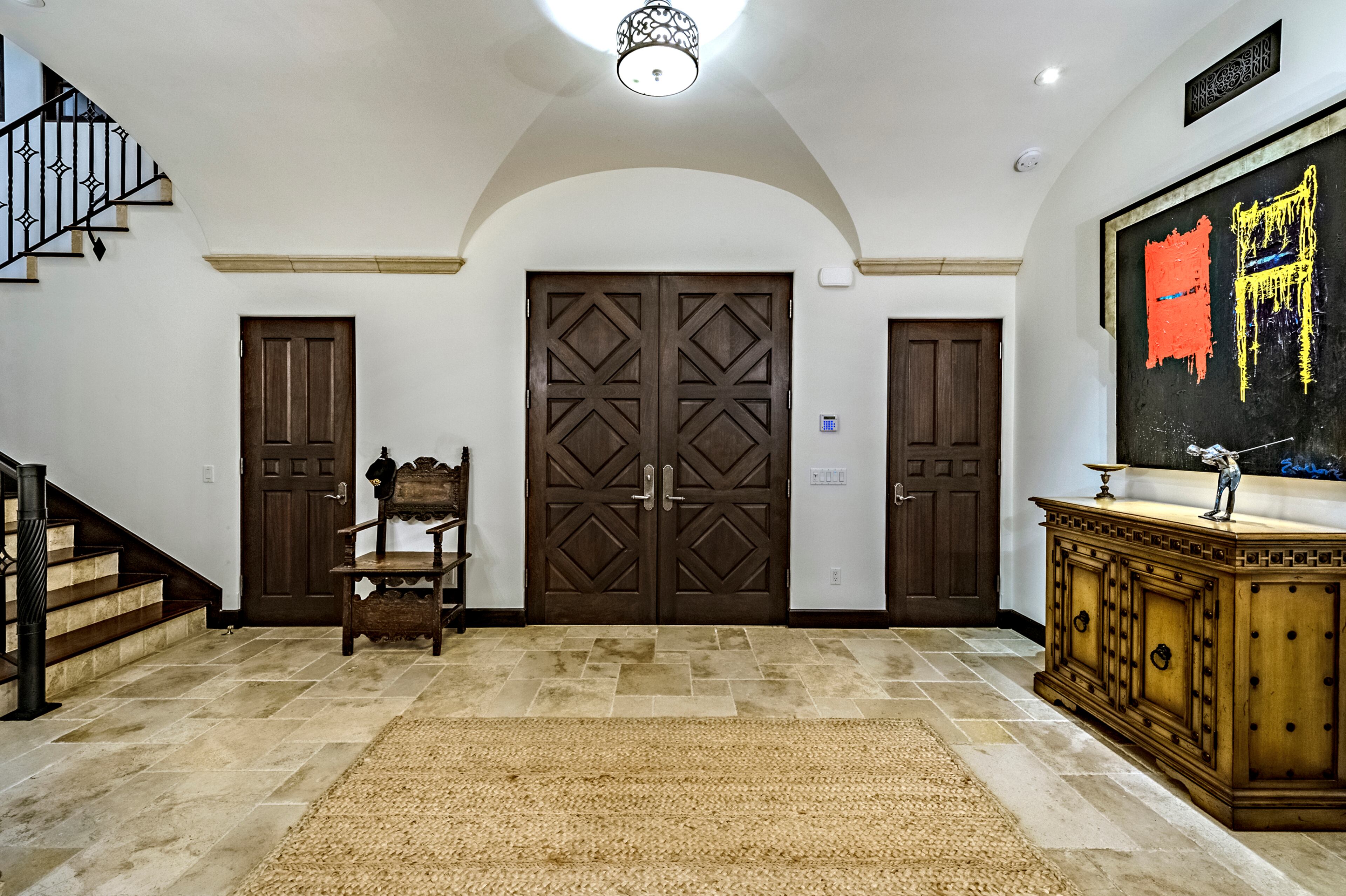 Heavy wood double doors open up to a vaulted ceiling in the entryway, which leads into the double-height living room. Rocky star and all-around action movie legend Sylvester Stallone has put his desert home in a gated La Quinta, Calif., community up for sale at $4.2 million. The 5,173-square-foot, four-bedroom, 4.5-bathroom home features details such as arched doorways, exposed beams, and plenty of space to hang his paintings, since he’s not just an actor—he’s an artist, too. Listing courtesy of Josh Reef, Hurwitz James Company