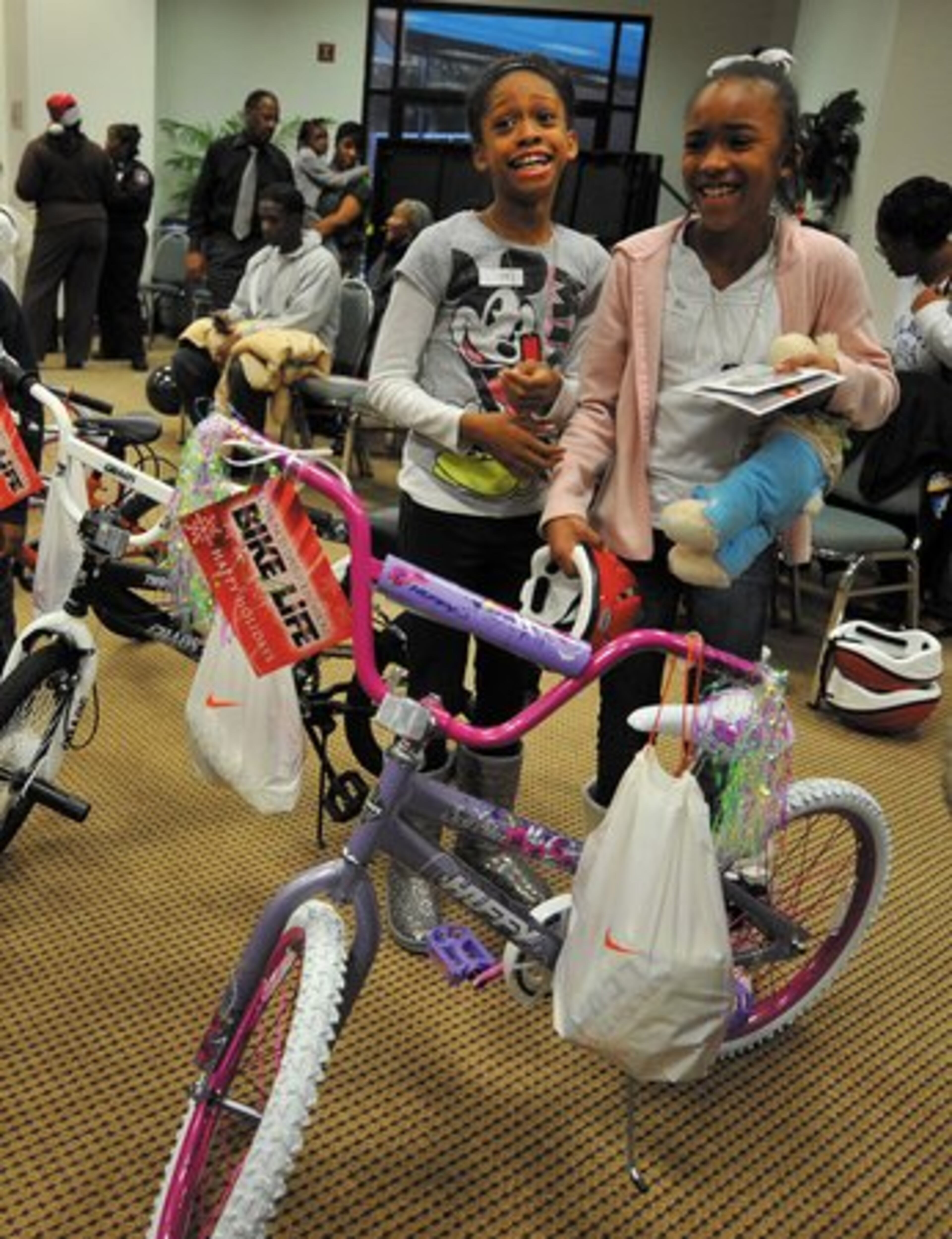 More than 100 bikes were given away in downtown Decatur on Tuesday as part of the 2nd Annual Chauncey Davis Foundation Bike for Life initiative. Davis is a defensive end for the Atlanta Falcons. Here, Amaya Davoll, 9, left, and Lauren Davis giggle over their new bikes.