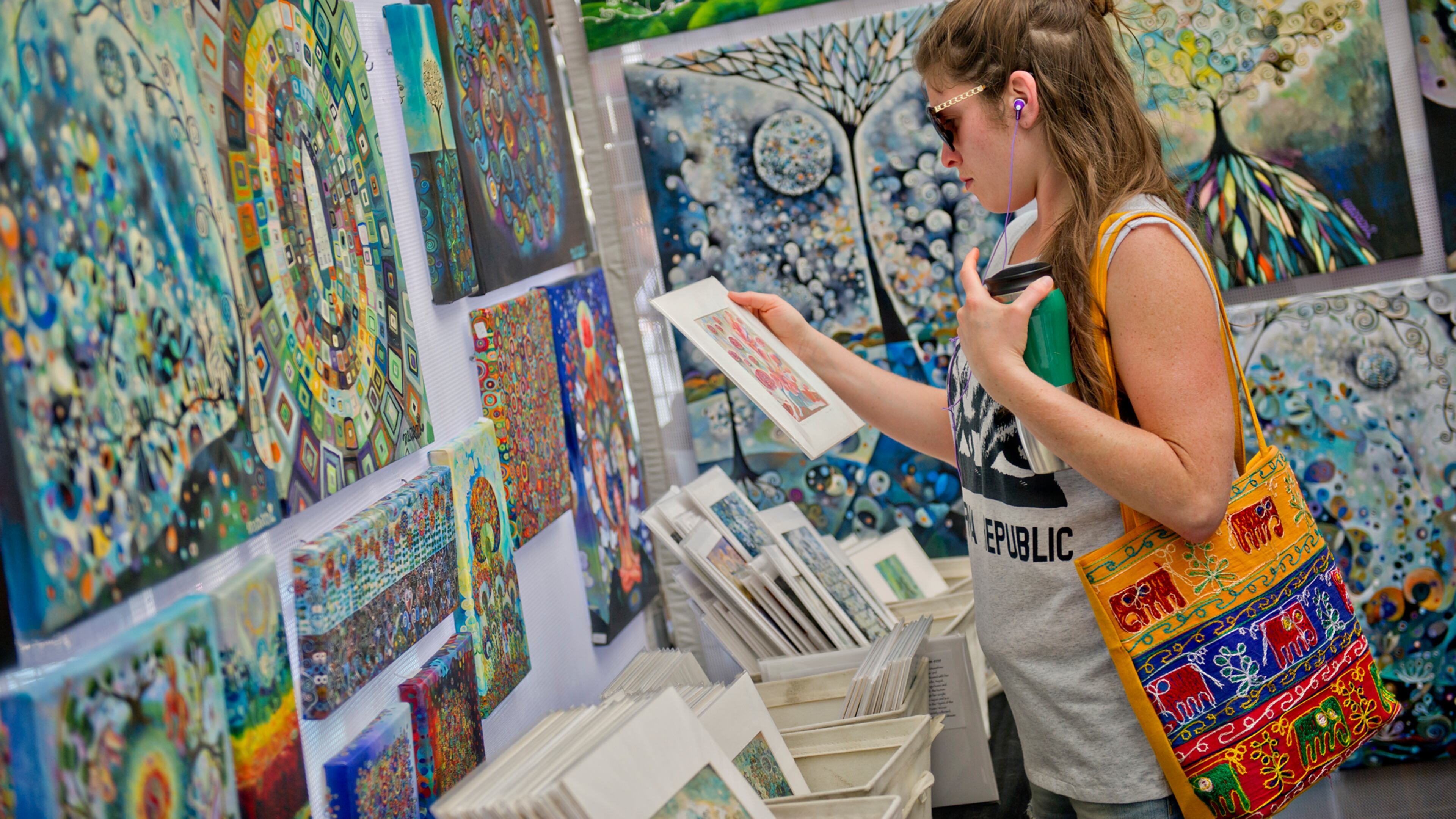 Leah Klatzker looks at paintings in Manami Lingerfelt's booth during the May-retta Daze Arts & Craft Festival at Glover Park in Marietta on Sunday, May 4, 2014.