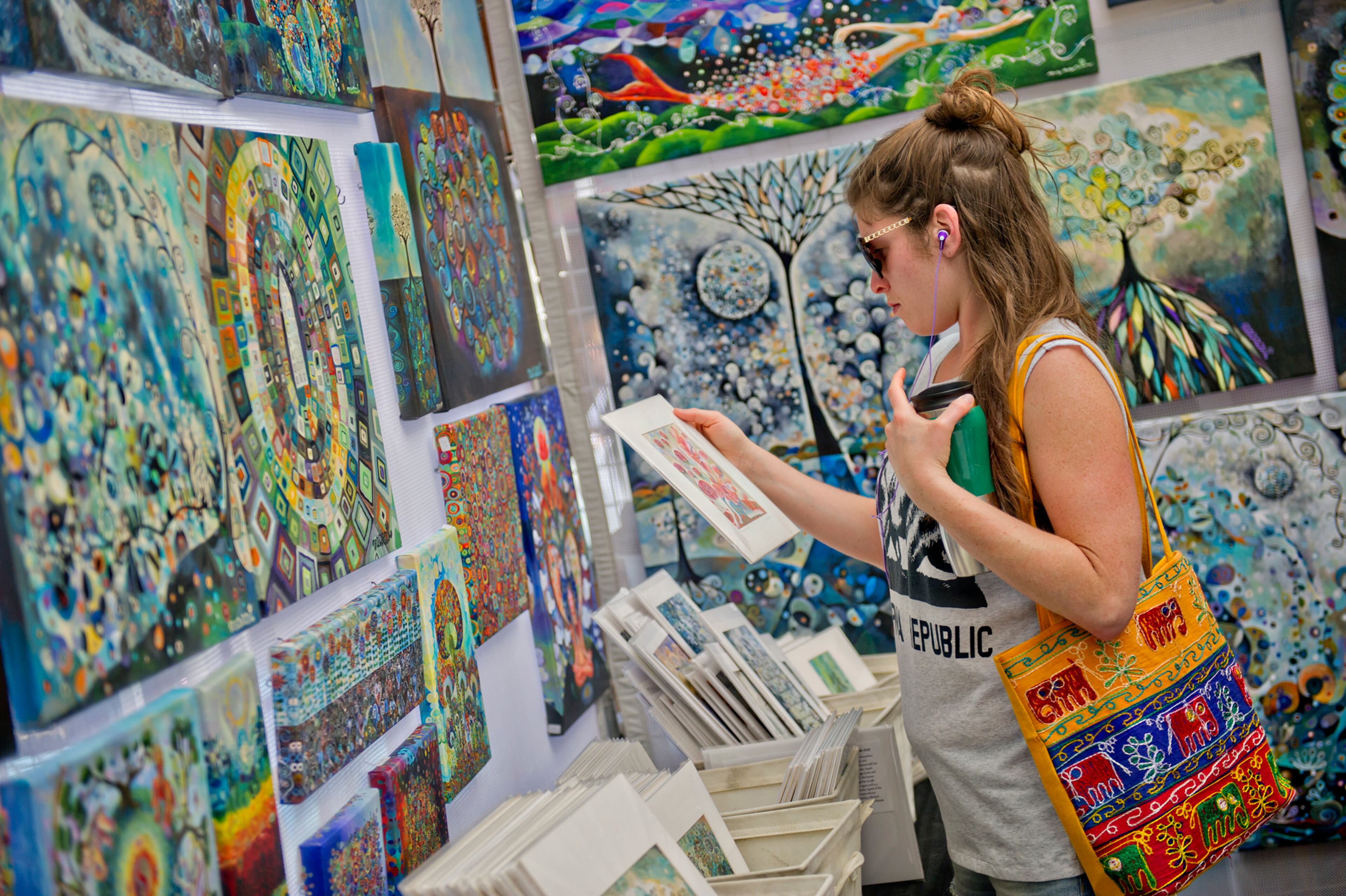 Leah Klatzker looks at paintings in Manami Lingerfelt's booth during the May-retta Daze Arts & Craft Festival at Glover Park in Marietta on Sunday, May 4, 2014.