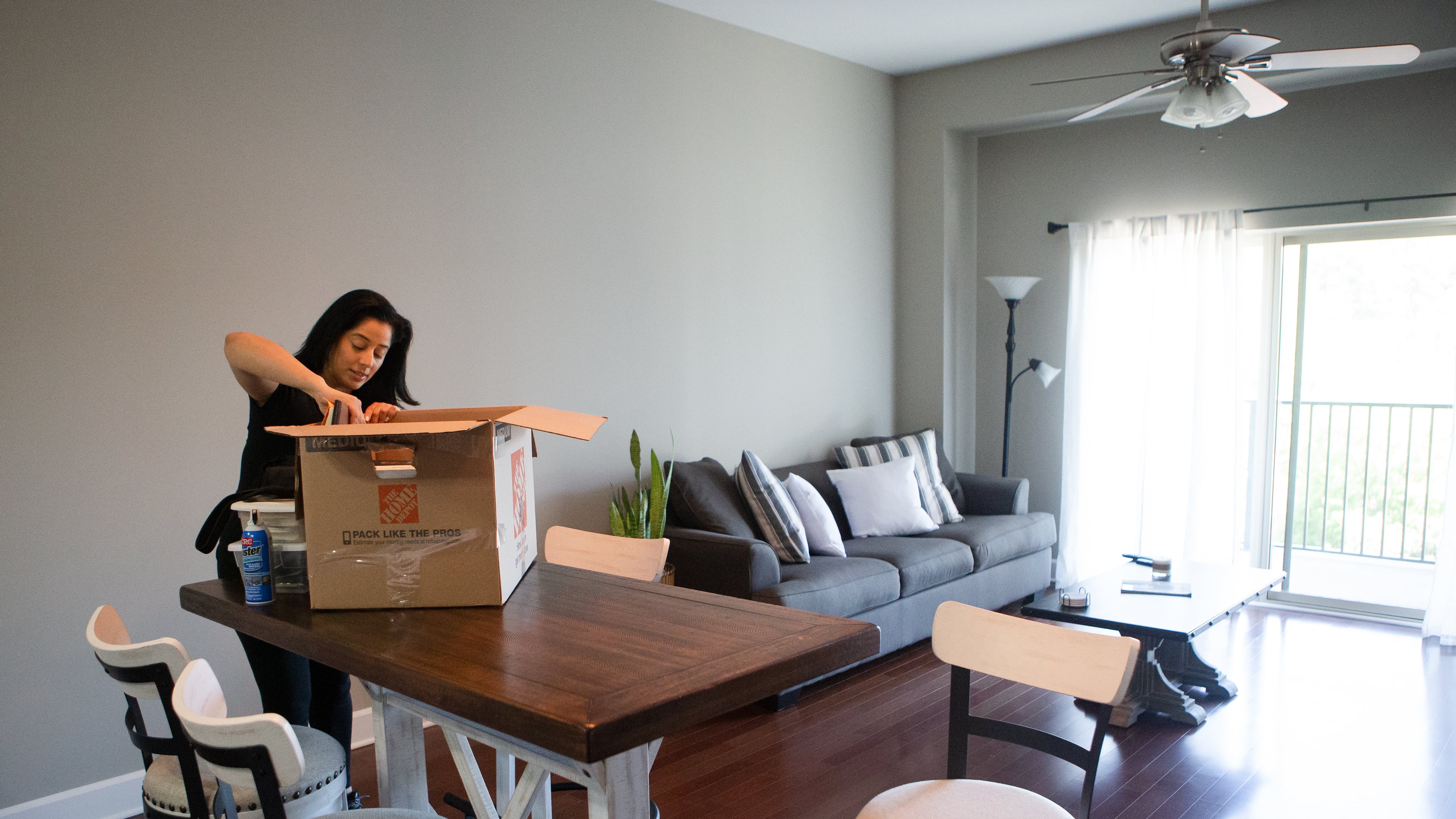 Michelle Enjoli unpacks a box at her apartment in Sandy Springs. Enjoli moved from a crowded area in Buckhead to a gated community in Sandy Springs after starting a business and transitioning to working at home full-time. (Christina Matacotta for The Atlanta Journal-Constitution)