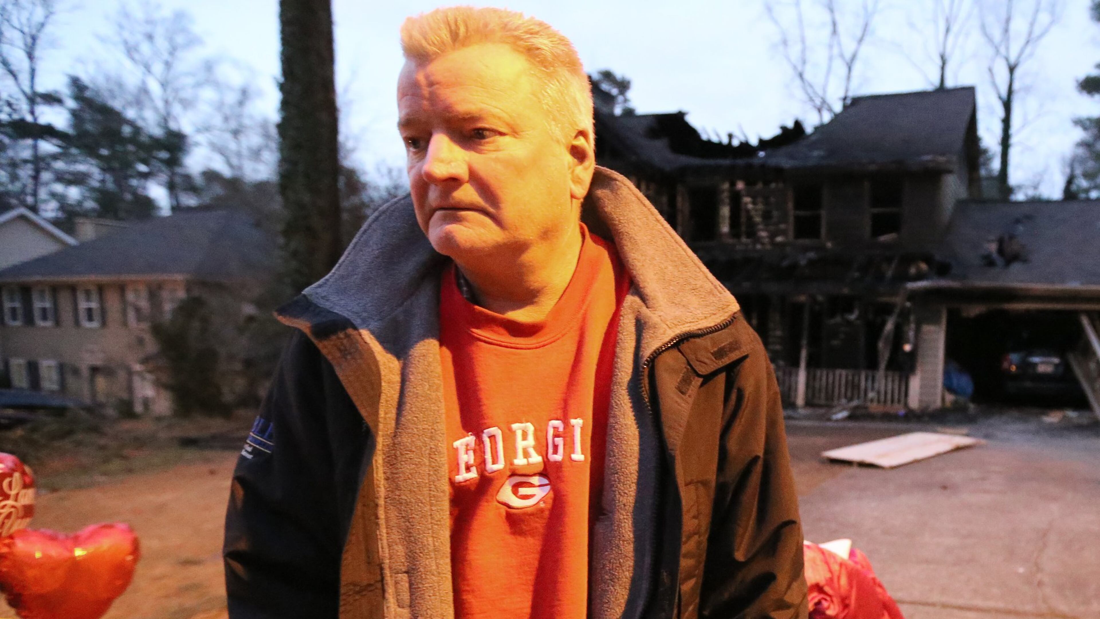 Brent Patterson stands in front of his gutted Tucker home on Wednesday night, Feb. 10, 2016, following a Tuesday night fire that killed his wife, their two daughters, and the family dog. (Ben Gray / bgray@ajc.com)