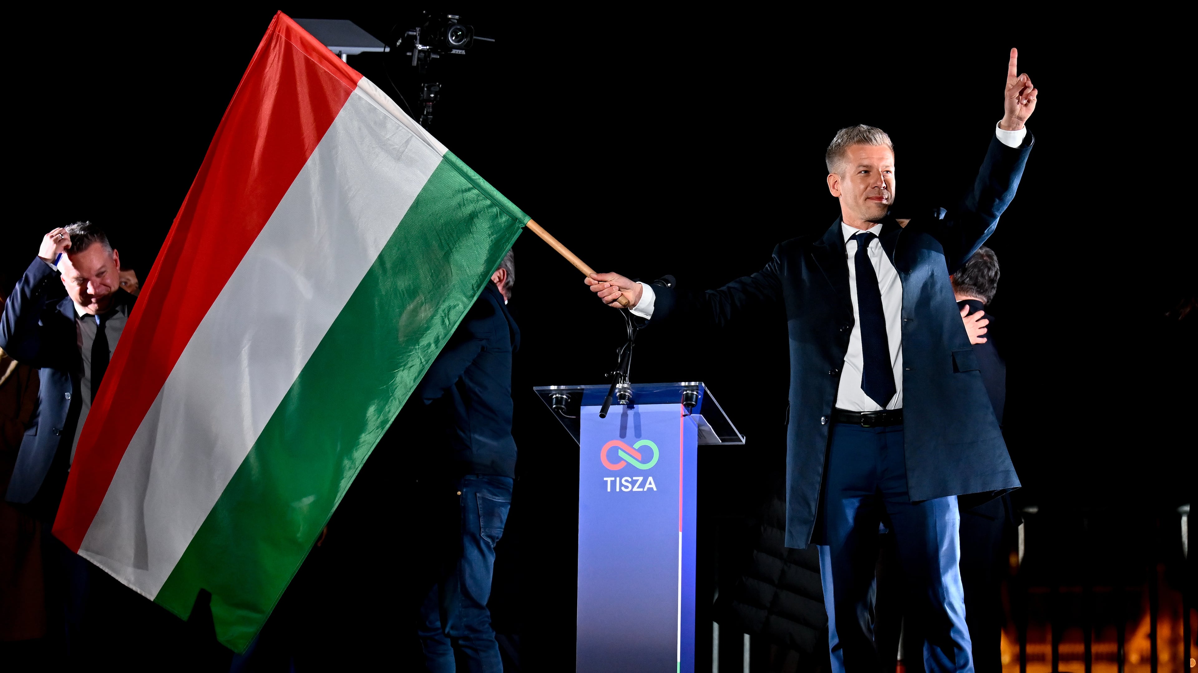 Peter Magyar, leader of the opposition Tisza party, waves the Hungarian flag following the announcement of the partial results of the parliamentary election, in Budapest, Hungary, Sunday, April 12, 2026. (AP Photo/Denes Erdos)