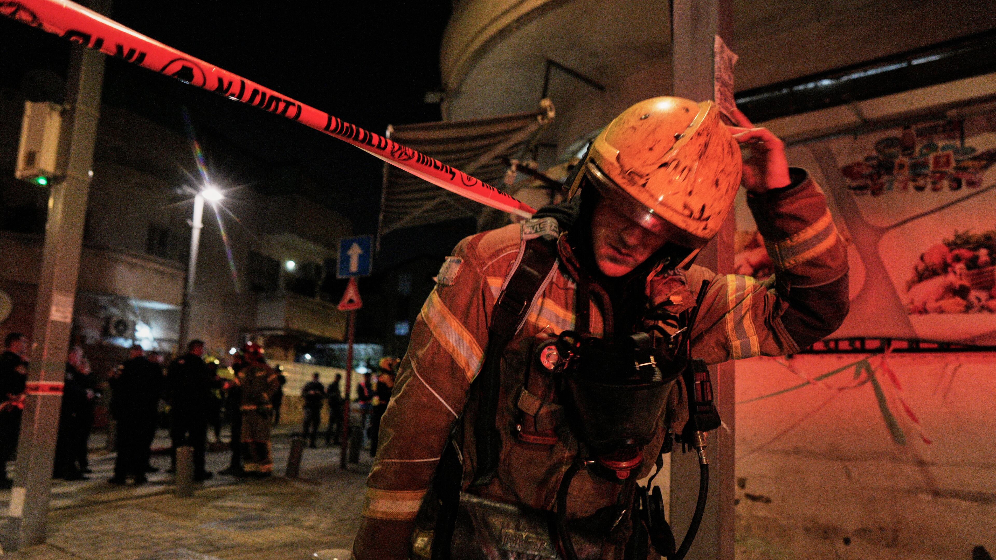An Israeli first responder walks from the site of a missile strike in Tel Aviv, Israel, early Saturday, March 28, 2026. (AP Photo/Maya Levin)