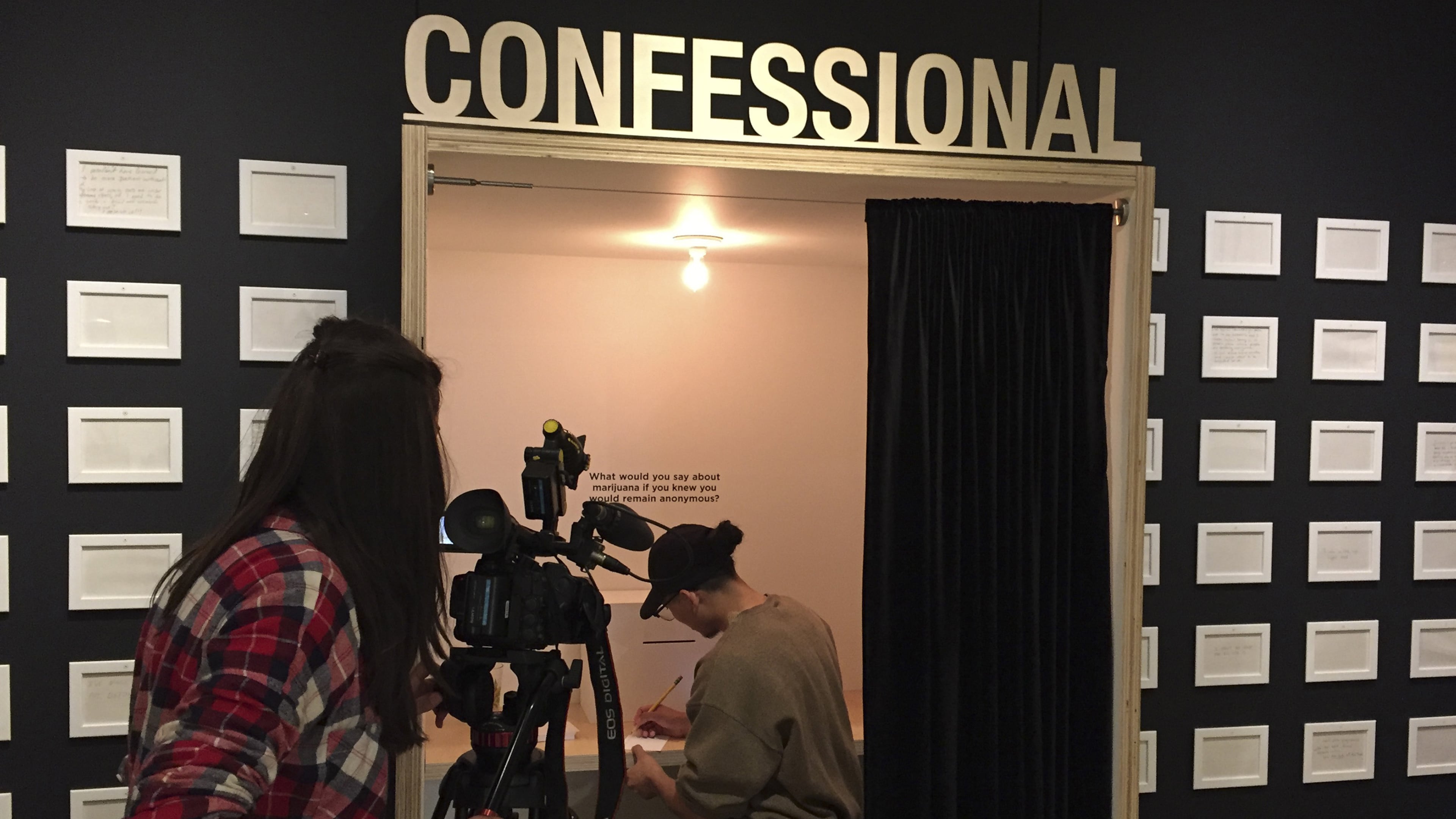 A local TV news cameraperson films a woman filling out a “cannabis confession” during a media preview of the Oakland Museum of California exhibitibion, “Altered State: Marijuana in California,” on April 14, 2016. (Sam McManis/Sacramento Bee/TNS)