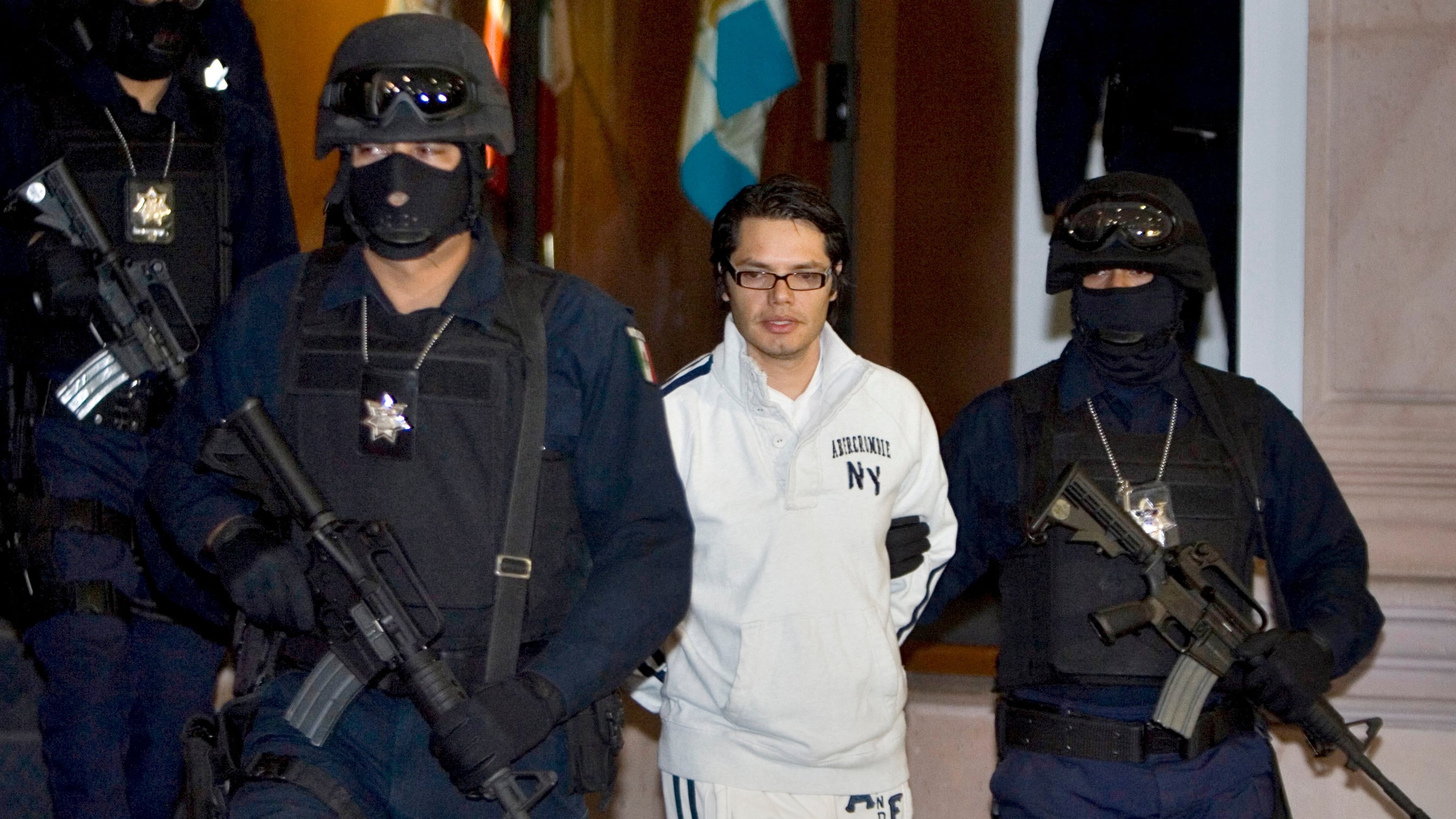 FILE - Federal police officers escort Vicente Carrillo Leyva, the alleged second-in-command of the Juarez Cartel, during his presentation to the media in Mexico City, April 2, 2009. (AP Photo/Eduardo Verdugo, File)