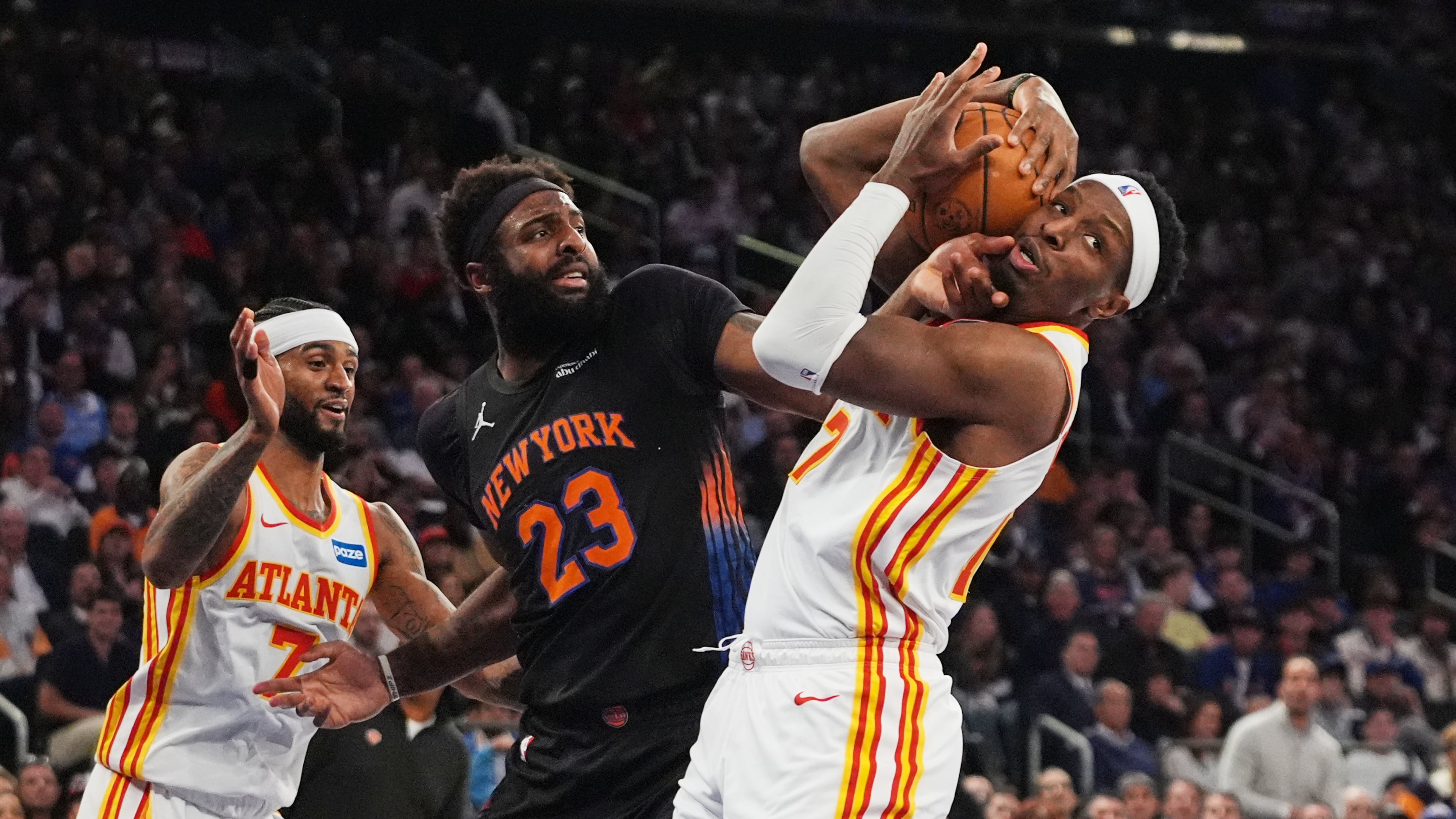 The Hawks' Nickeil Alexander-Walker (right) fights for control of the ball with the Knicks' Mitchell Robinson (center) during Game 5 of the first-round playoff series April 28, 2026, in New York. (Frank Franklin II/AP)