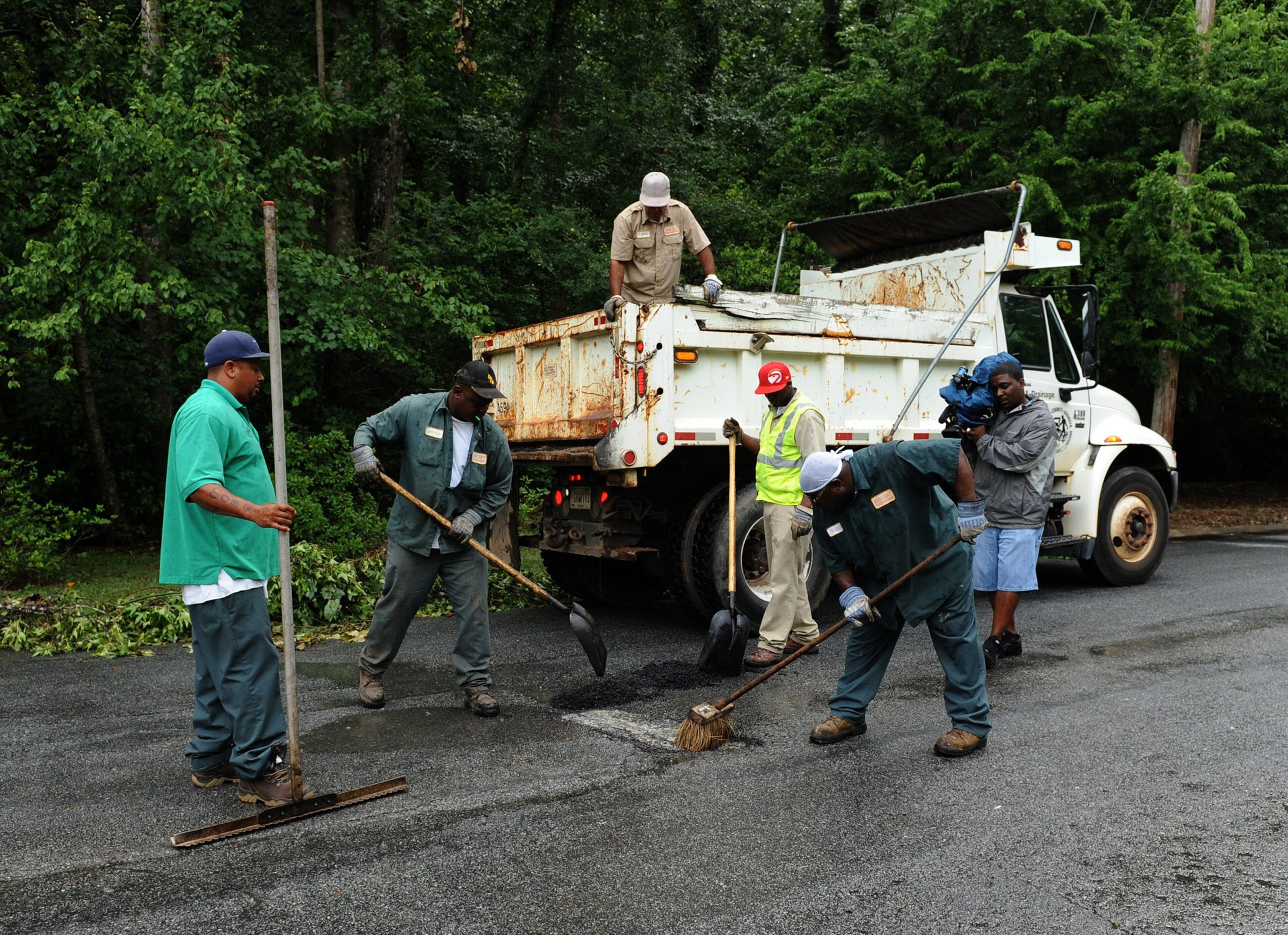 Workers from DeKalb County work on paving over a pothole on Friday, June 13, 2012. JOHNNY CRAWFORD / JCRAWFORD@AJC.COM.
