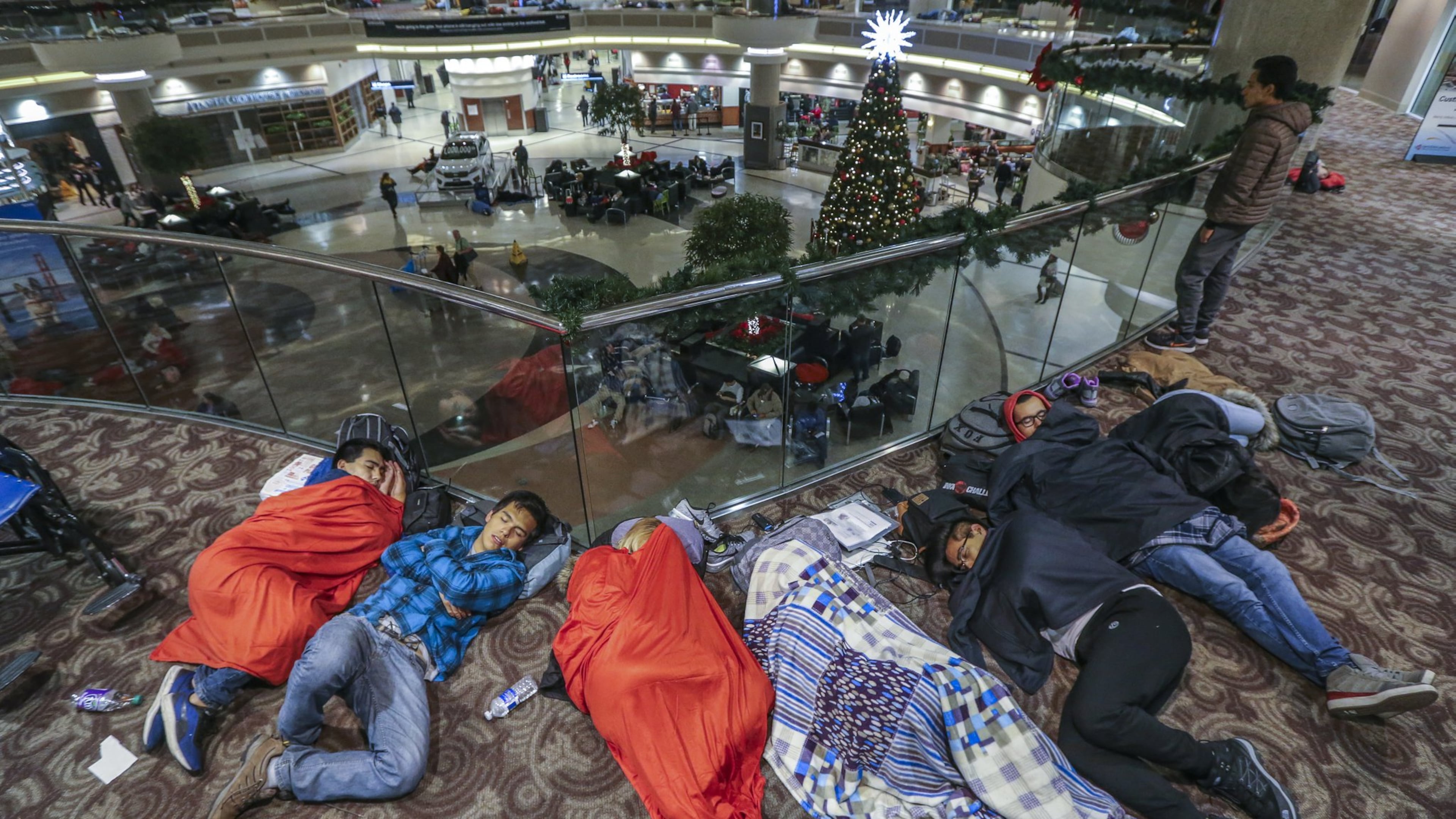 Many stranded travelers slept in the atrium at Hartsfield-Jackson International Airport Sunday night, after a massive power outage forced airlines to cancel more than 1,100 flights and created a logistical nightmare during the already-busy holiday travel season. JOHN SPINK/JSPINK@AJC.COM