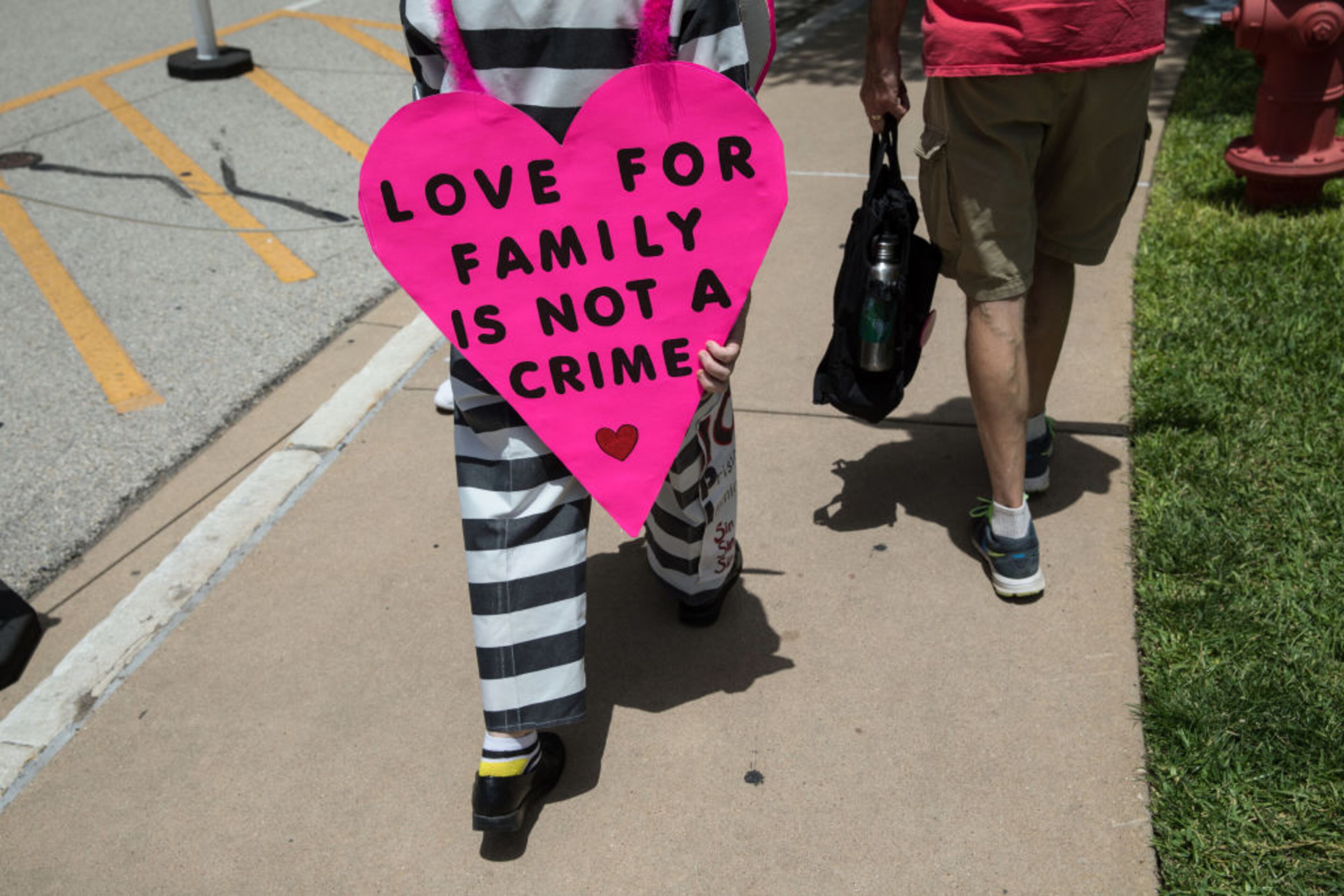 AUSTIN, TX - JUNE 30: Heidi Turpin wears a prison uniform costume as she and her husband Jim Turpin protest the Trump administration's immigration policies at a rally outside of the Texas Capitol in Austin, Texas, on June 30, 2018. Demonstrations are being held in cities across the U.S. Saturday to call for the reunification of separated families and to protest the detention of children and families seeking asylum at the border. (Photo by Tamir Kalifa/Getty Images)