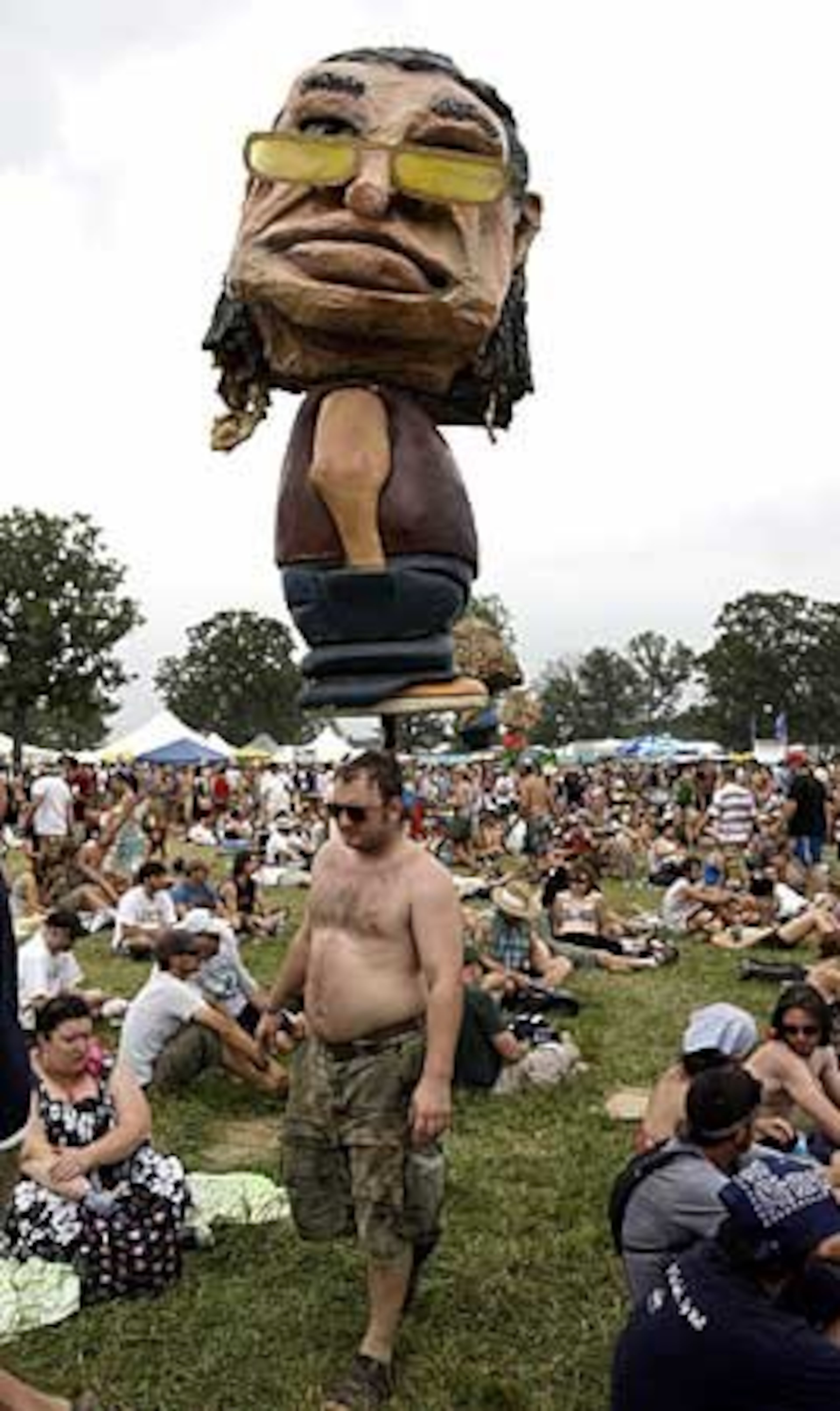 A large bobble-head doll towers over the crowd at the Bonnaroo music festival.