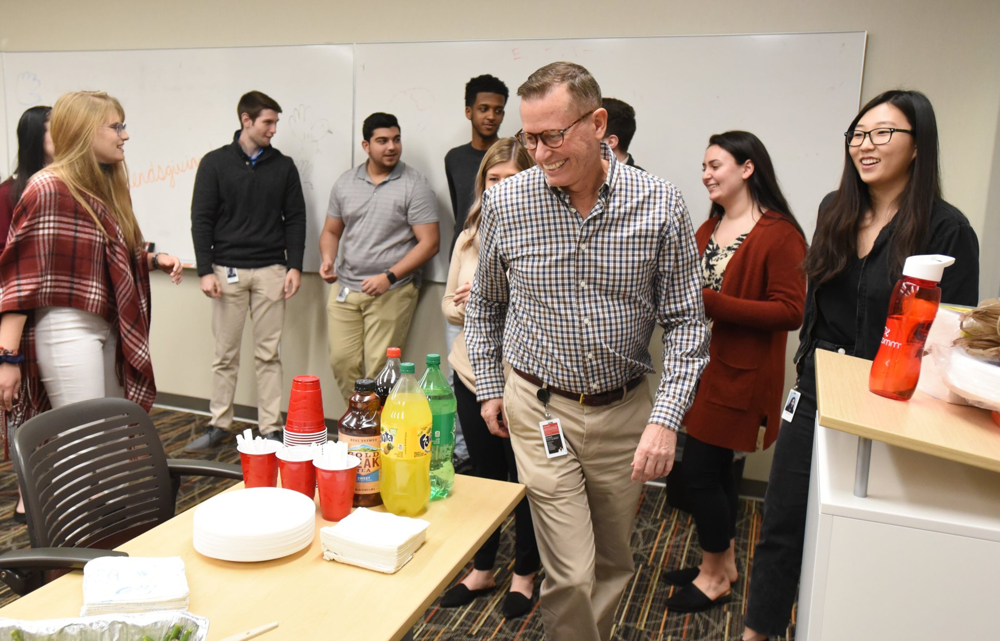Dean Matthews (foreground), senior director of learning and development, leads a “Friendsgiving” event with college student interns from the University System of Georgia at InComm, a financial technology company, in Atlanta on Nov. 19, 2019. The interns are learning and utilizing communication skills at InComm. The University System of Georgia is working on revamping its core curriculum for the first time in two decades. The plan is to make it more flexible for 21st-century learning as more adults seek continuing education for their careers.
