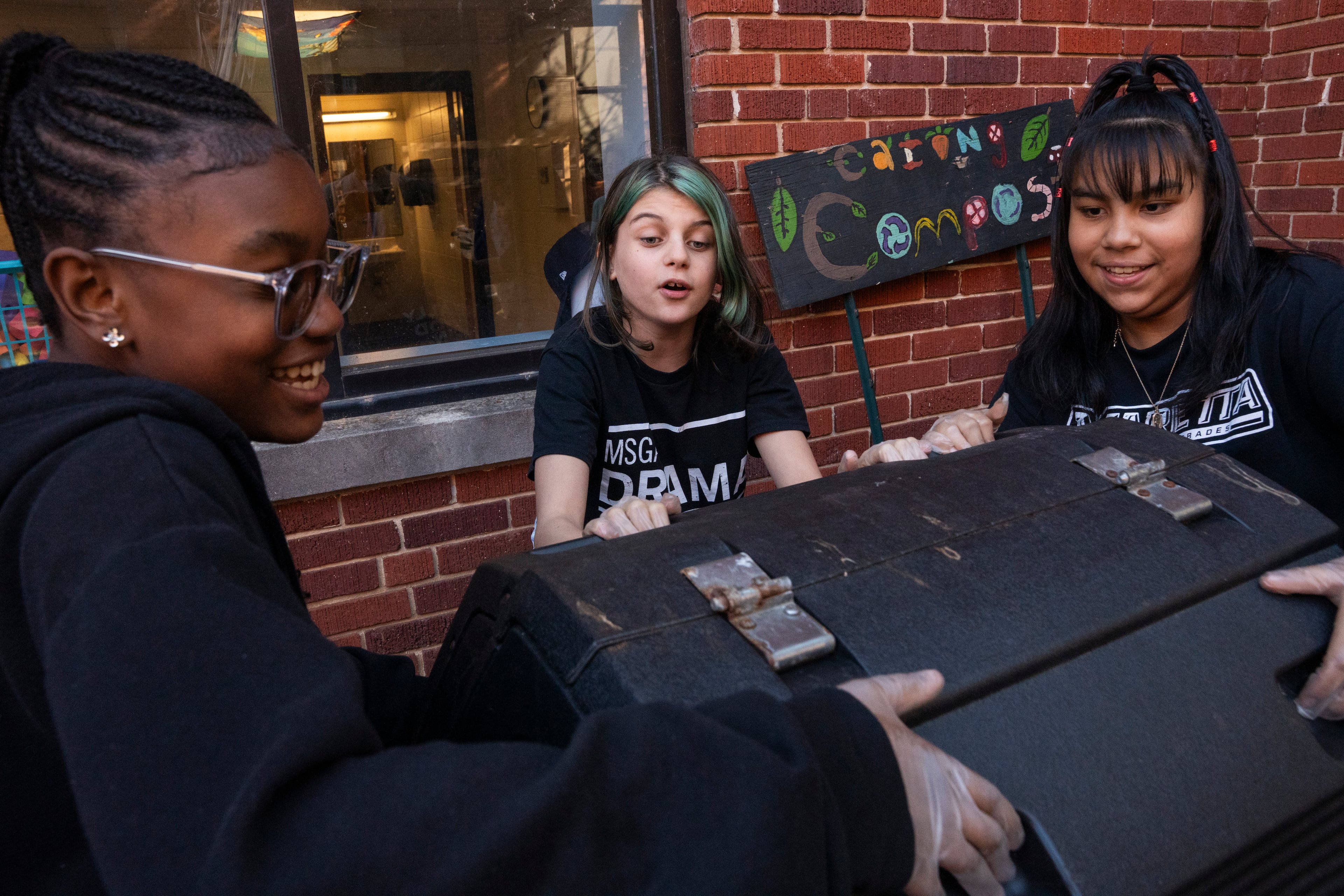 Marietta Middle School seventh graders Yadajah Gresham (left), Addelynn Covingtree (center) and Elissa Ramirez participate in the Compost Connectors program on Monday, Nov. 17, 2025. (Olivia Bowdoin for the AJC)